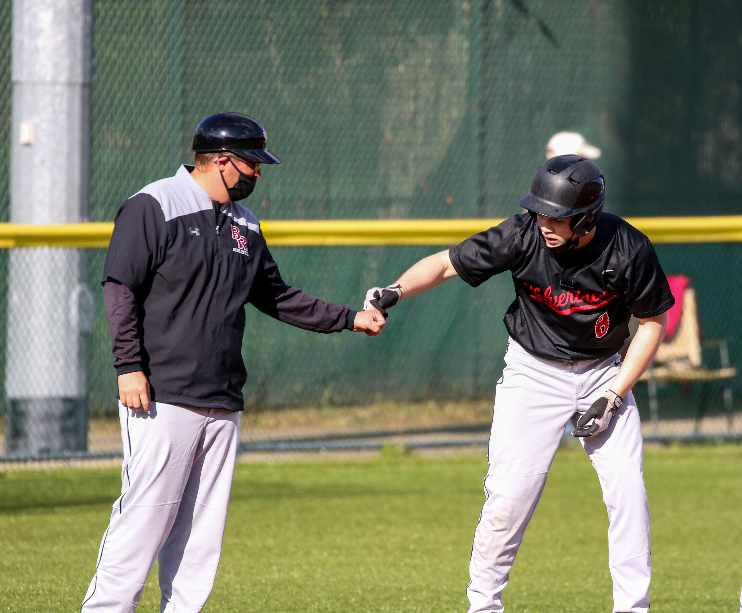  Bolivar-Richburg head coach Dustin Allen, left, provides a fist bump for senior Wayne Karnuth (8) after reaching third base safely during Monday night’s home contest against Cuba-Rushford. [Chris Brooks/WellsvilleSports.com] 