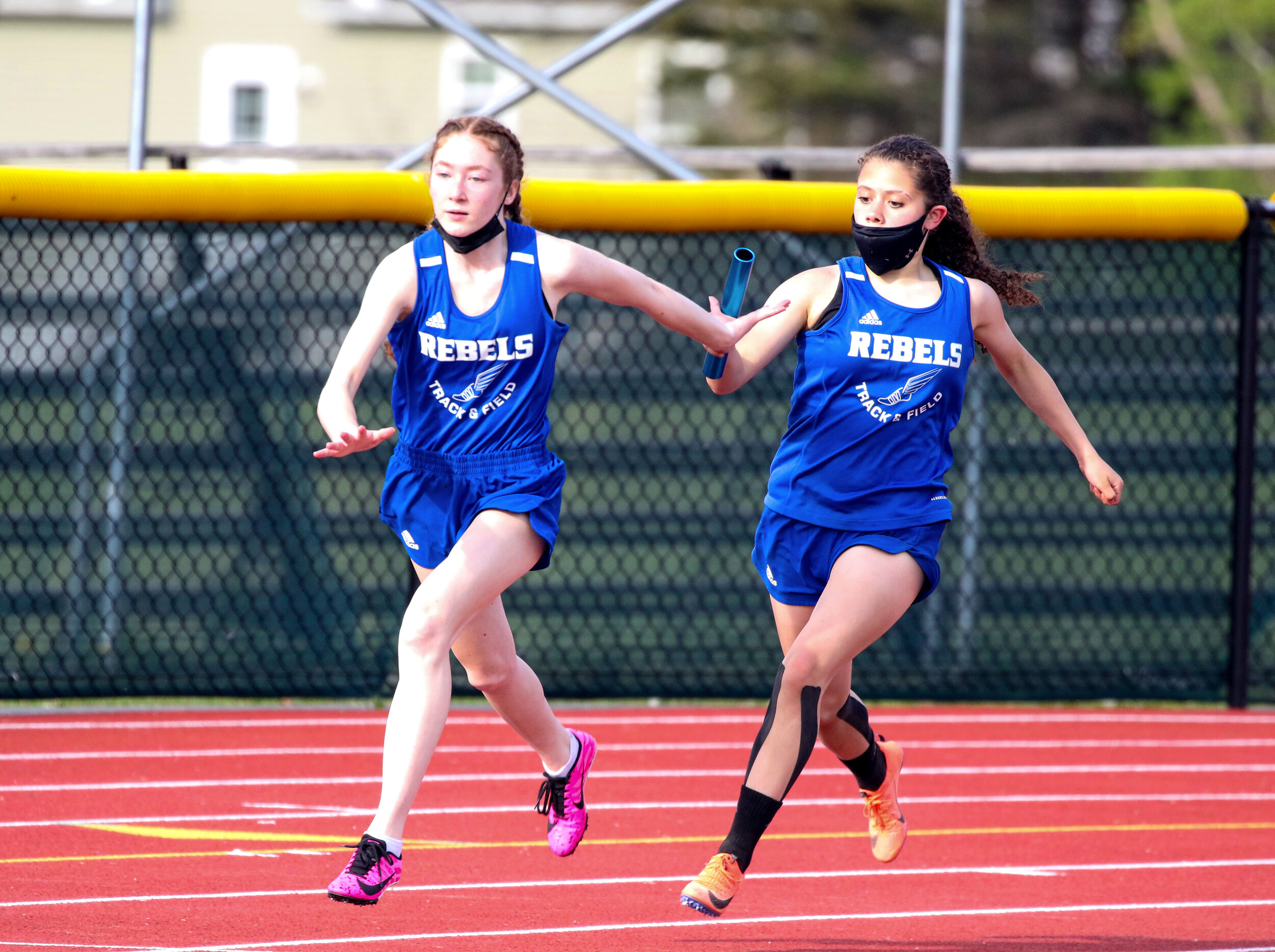  Cuba-Rushford’s Sofia Riquelme, right, hands the baton off to her teammate Natalie Goble, left, as they compete in the 400 relay event of Wednesday’s tri-meet in Wellsville. [Chris Brooks/WellsvilleSports.com] 