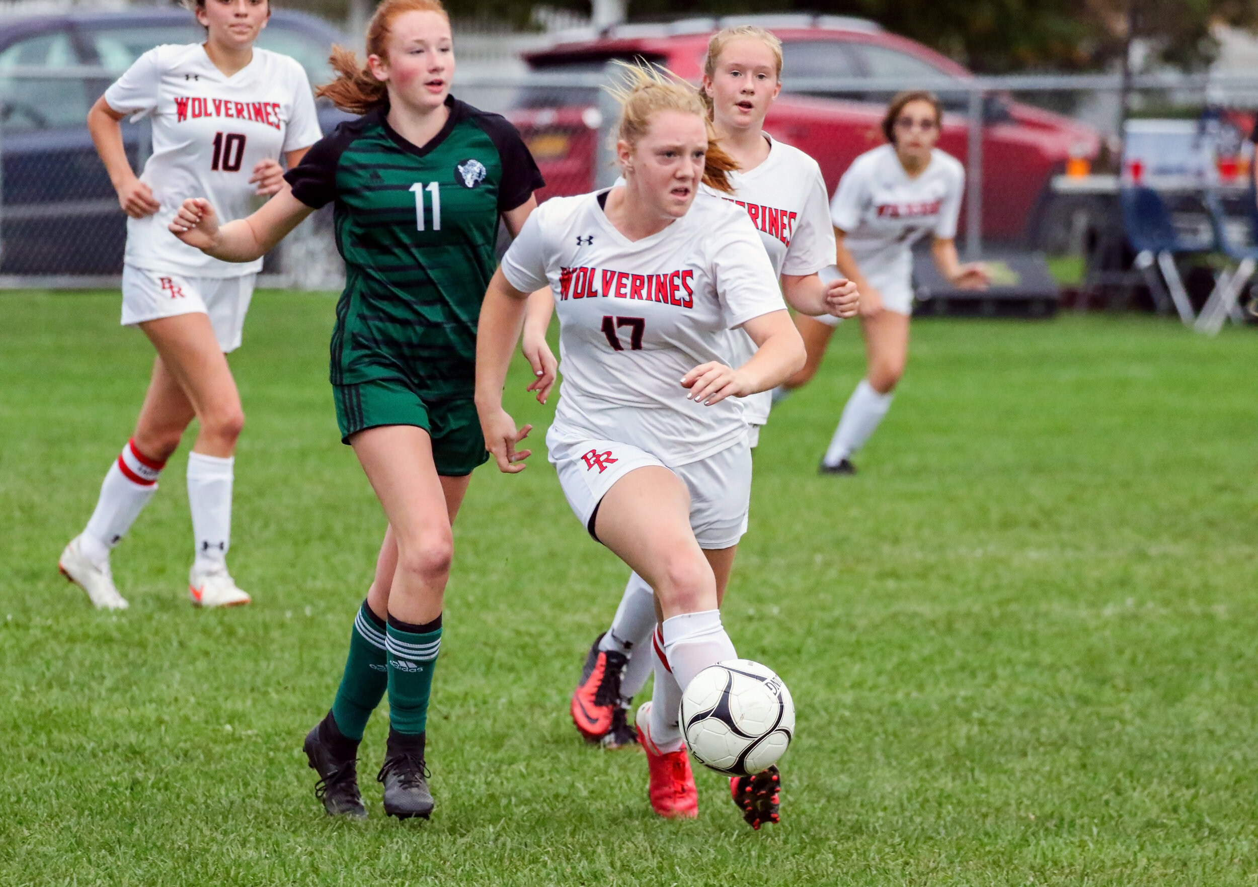  Bolivar-Richburg senior Jessica Majot (17) sends the  ball downfield, as Genesee Valley/Belfast sophomore Abby Sullivan (11) races over to defend during Saturday evening’s road contest in Belfast. [Chris Brooks/WellsvilleSports.com] 