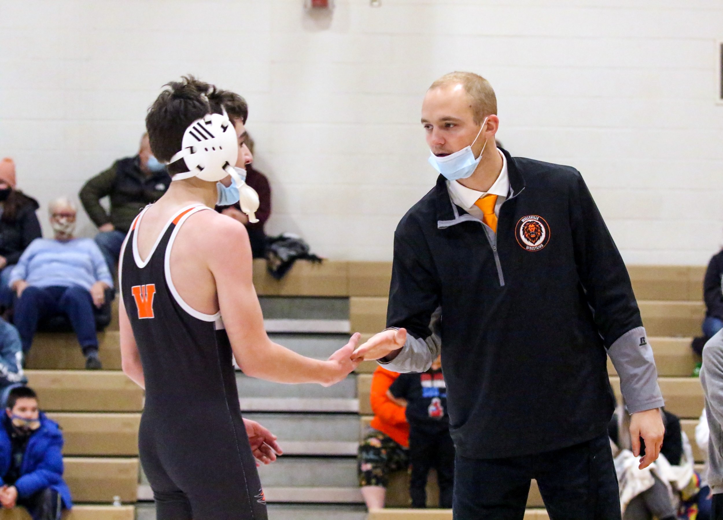  Wellsville head coach Tyler Carman, right, hands out a high five to Adam Iantorno, left, for his hard effort during his bout at 118 pounds during Tuesday night’s home match against Avoca/Prattsburgh/Hammondsport. [Chris Brooks/WellsvilleSports.com] 