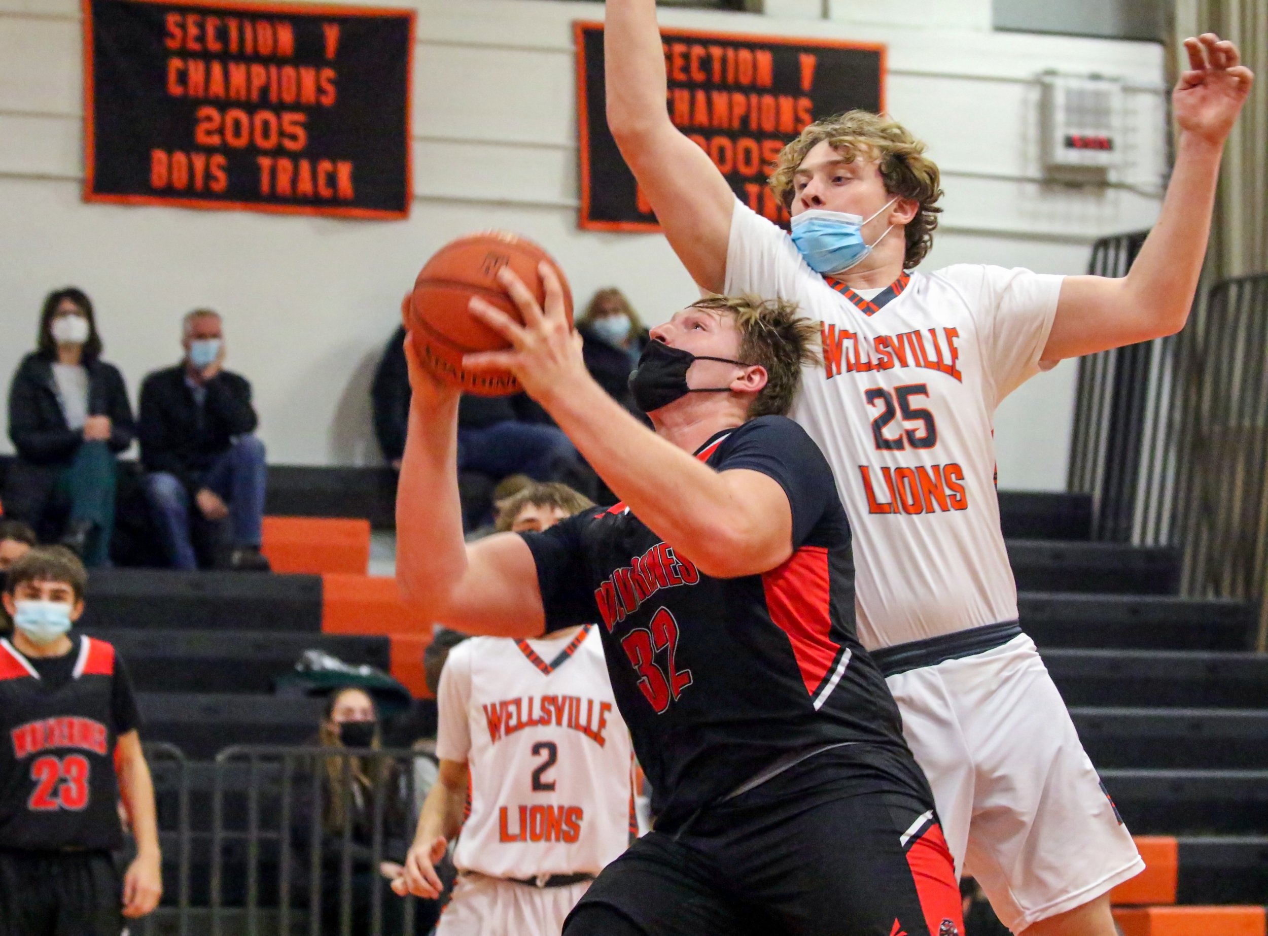  Bolivar-Richburg senior Cam MacDonell (32) goes up for the basket, as Wellsville senior Connor Ferguson (25) looks to block the shot during Tuesday night’s road contest in Wellsville. [Chris Brooks/WellsvilleSports.com] 