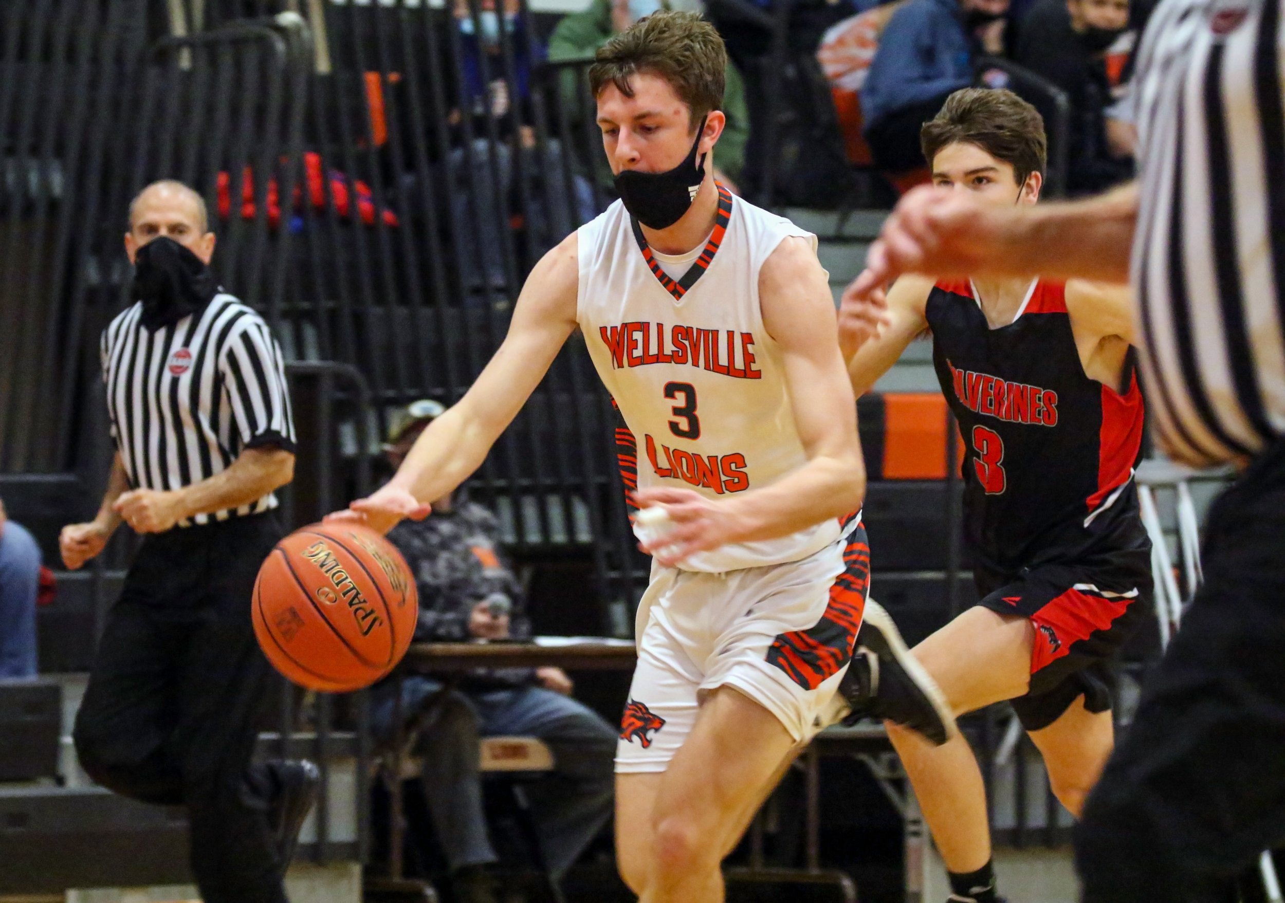  Wellsville senior Alex Perkins (3) pushes the pace down court while Bolivar-Richburg senior Wyatt Karnuth, off-center, gives chase on the way back down during Tuesday night’s home contest in Wellsville. [Chris Brooks/WellsvilleSports.com] 