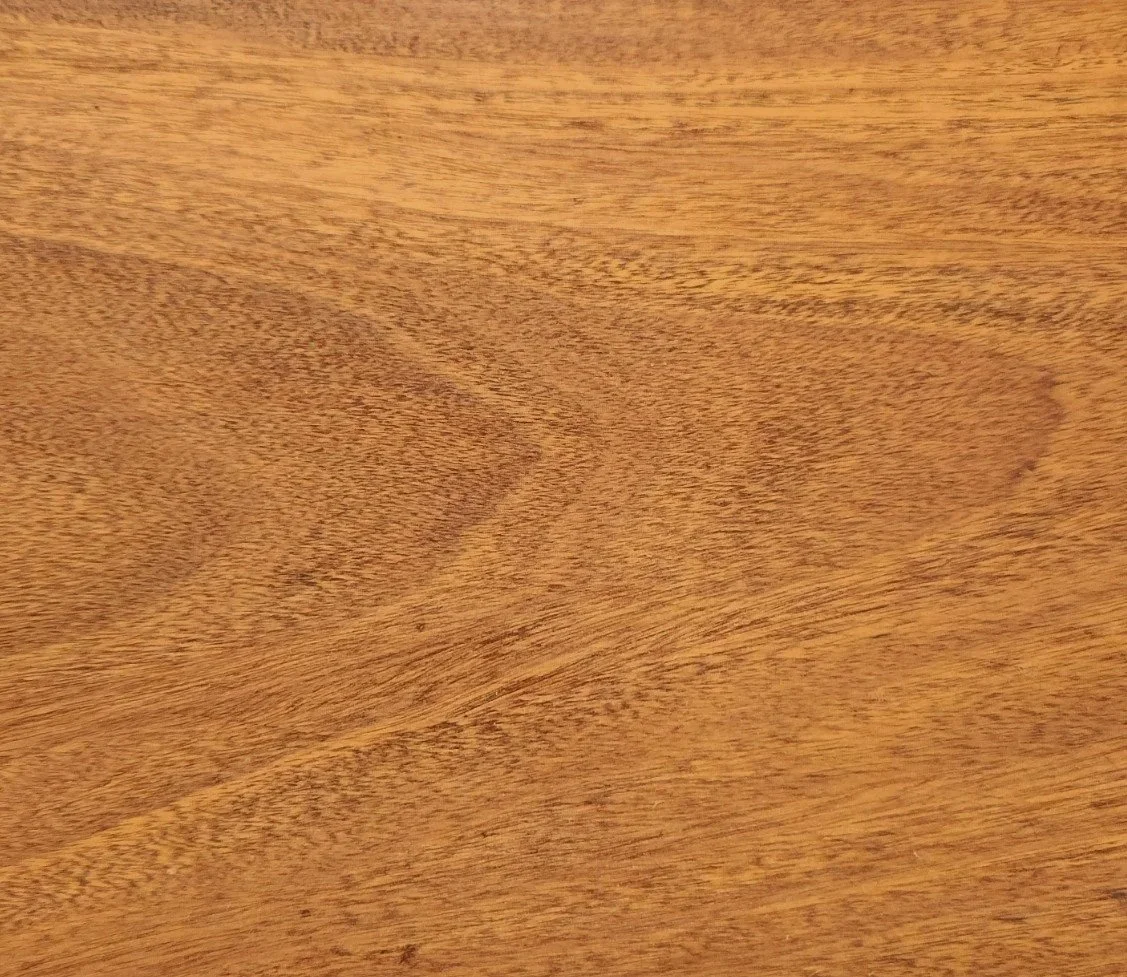 Close-up of a wooden surface with a smooth finish and visible wood grain.