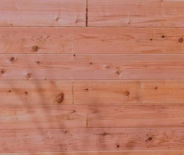 Close-up of a wooden surface with visible wood grain and knots.