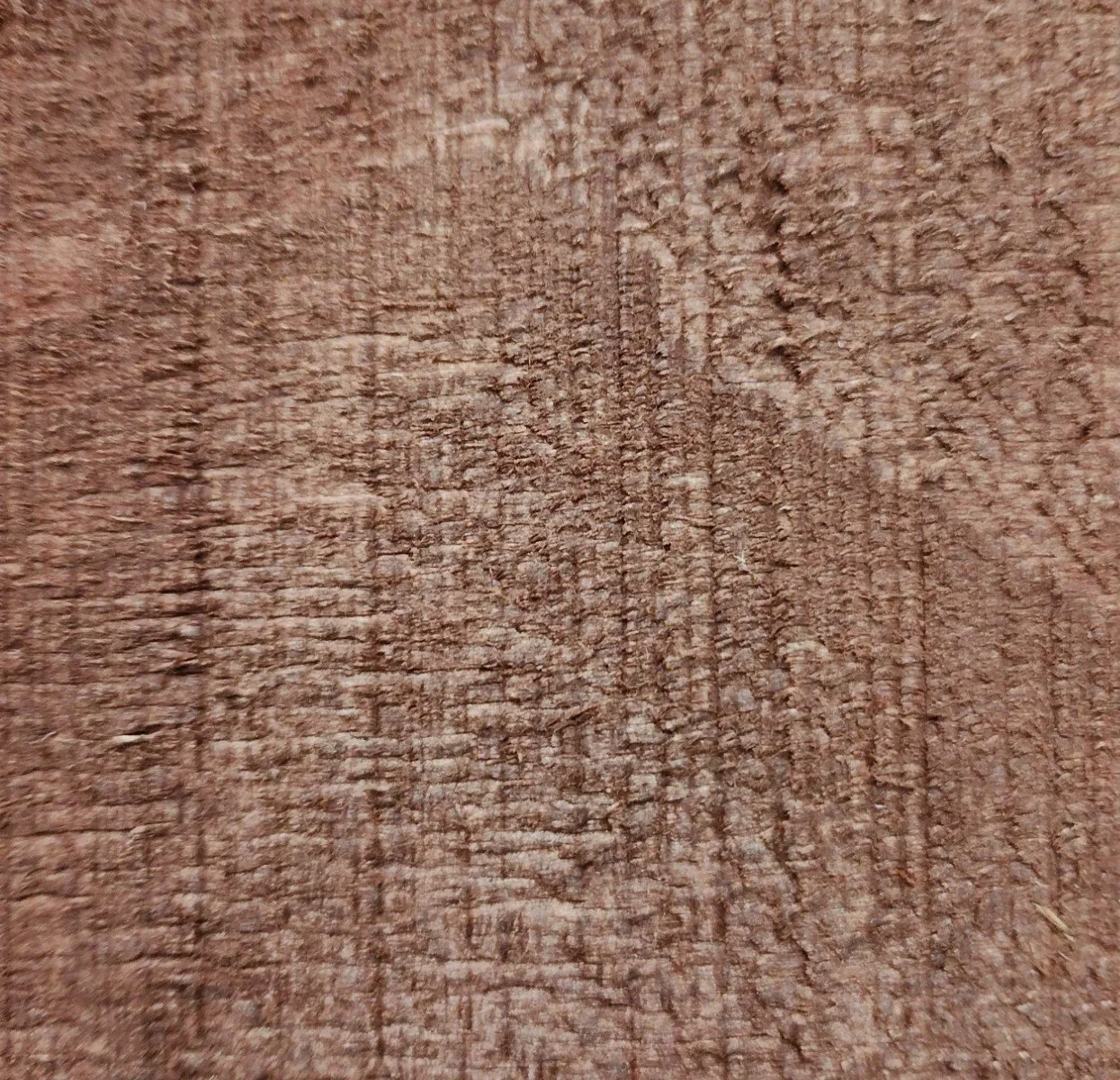 Close-up of a textured wooden surface with visible grain patterns.