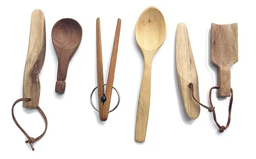 Five wooden kitchen utensils with leather or string loops