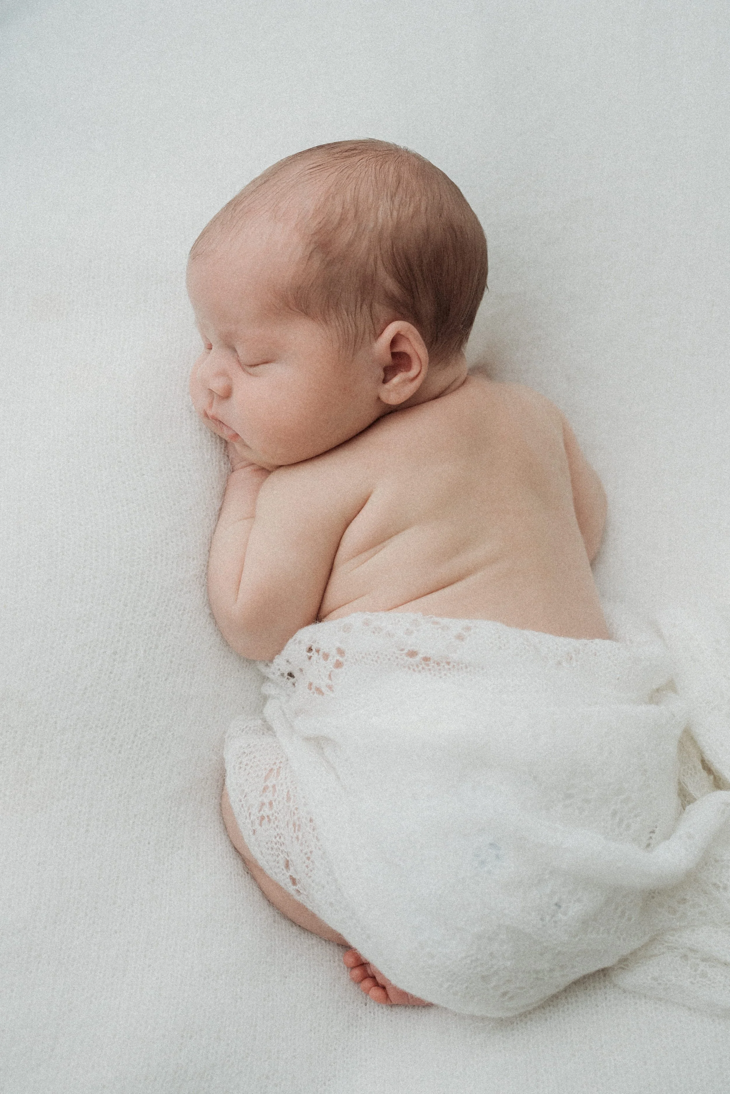 baby sleeping and snuggled up wrapped in a blanket