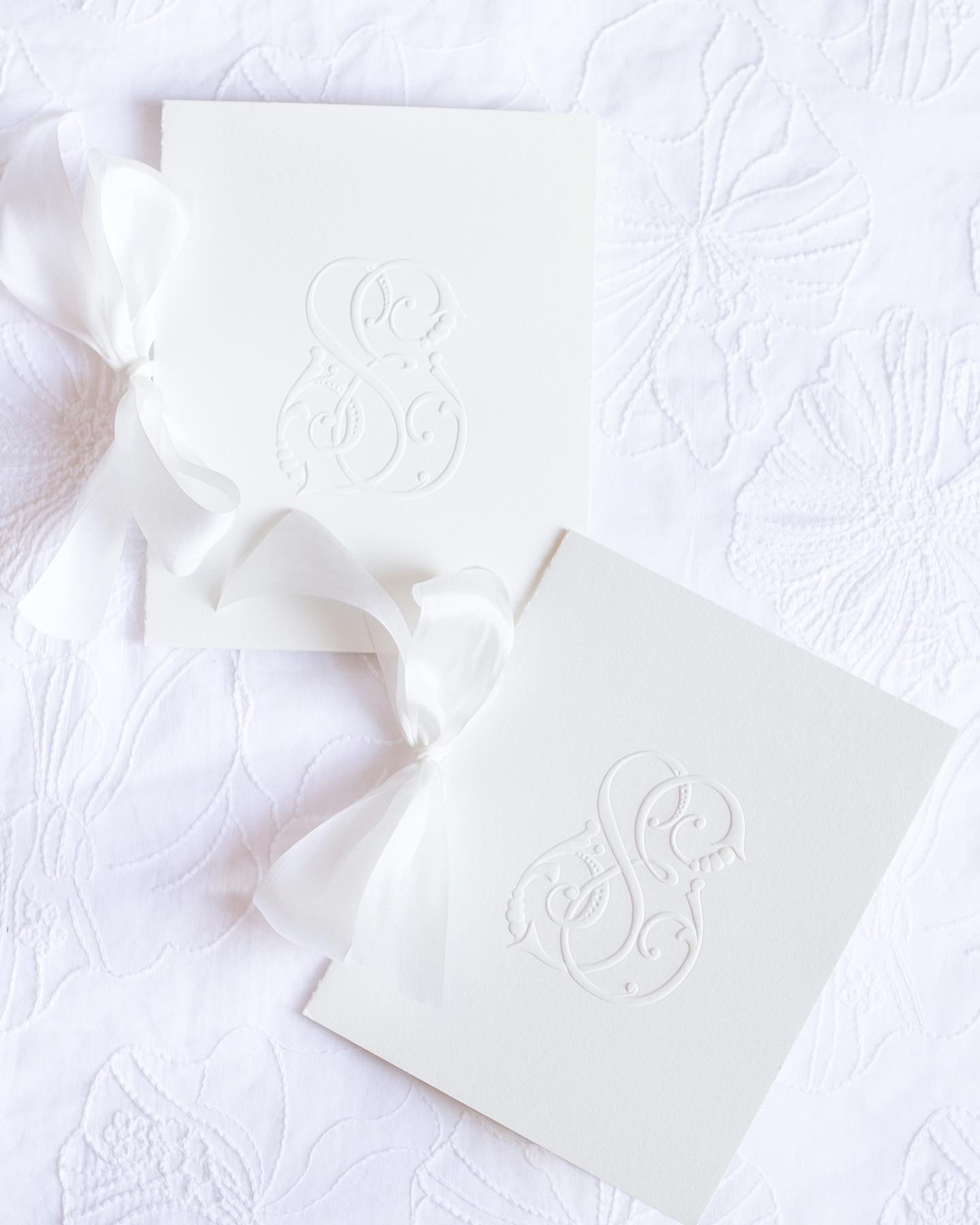 You can never go wrong with a classic white program booklet for your wedding ceremony! This program features the bride and grooms&rsquo; multi sculpt, embossed custom monogram and assembled together with a white silk ribbon for a subtle, yet elegant 