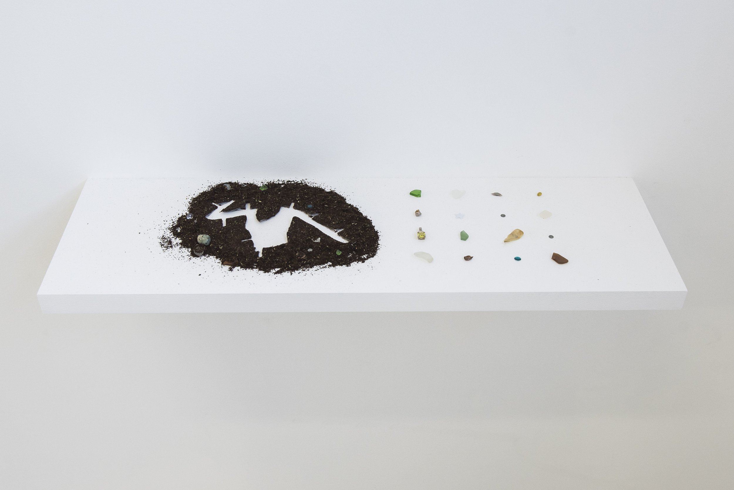   dig site , 2021   McIver’s ‘Goroka Espresso’ coffee grounds, nettle tea, incense ashes, epoxy resin, contact paper, various found objects.   Shelf dimensions: 60 x 24 x 3.8 cm.   Image courtesy of Jordan Halsall. 
