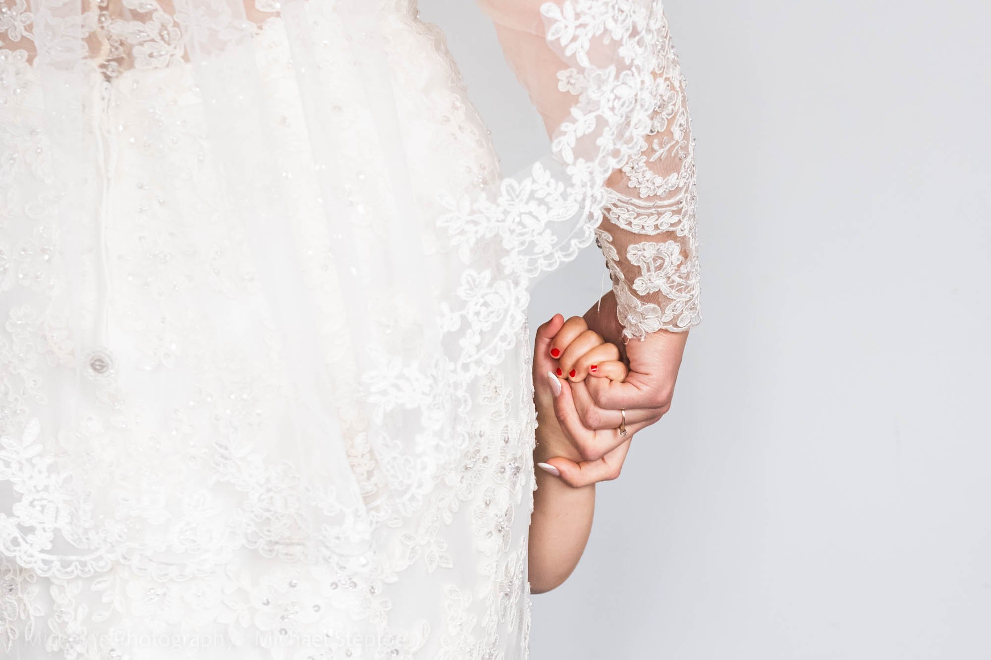 the bride, fully ready, caught in a private moment with her daughter’s hand in hers.