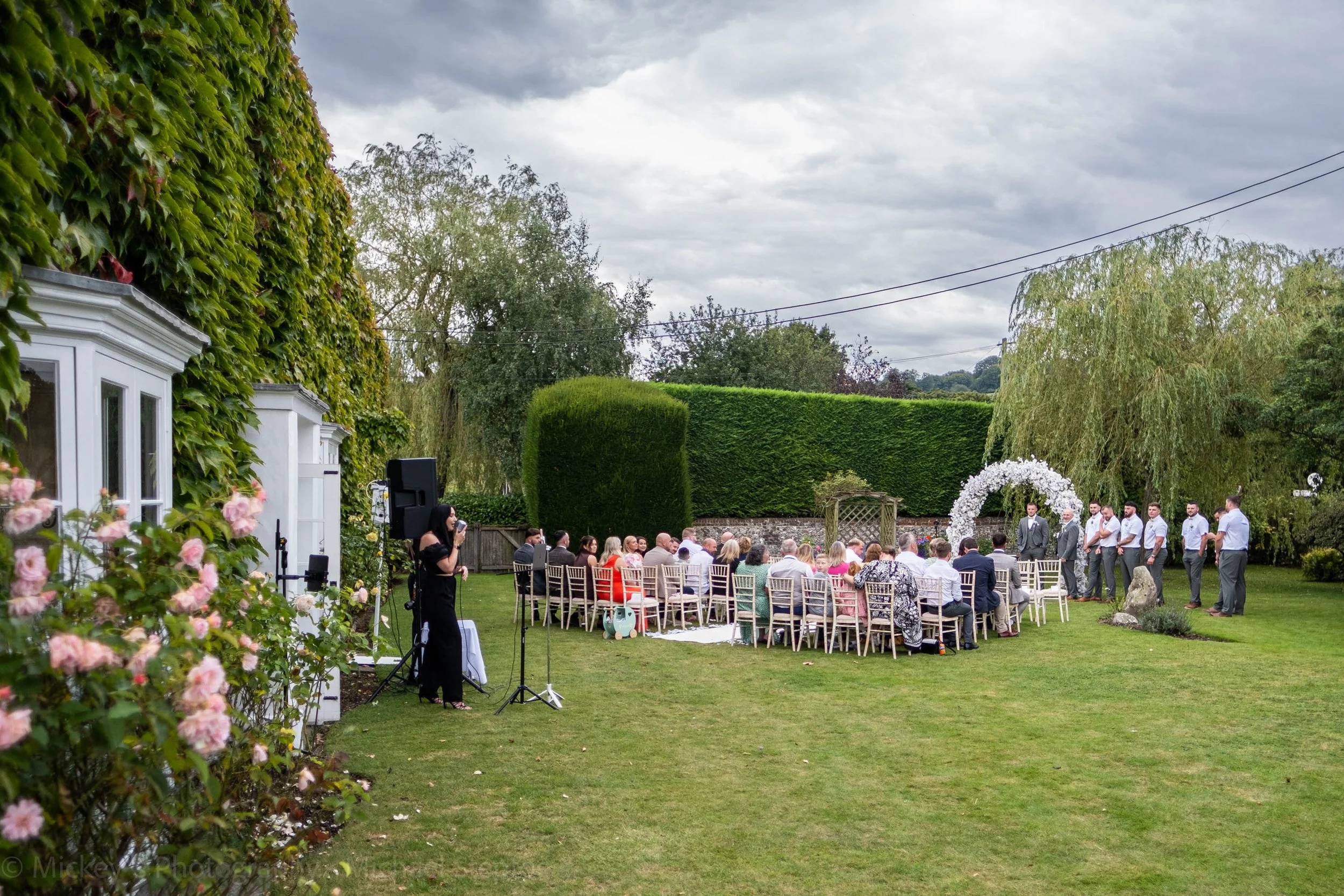 Guests and the groom with his groomsmen waiting for the bride to walk down the Aisle.
