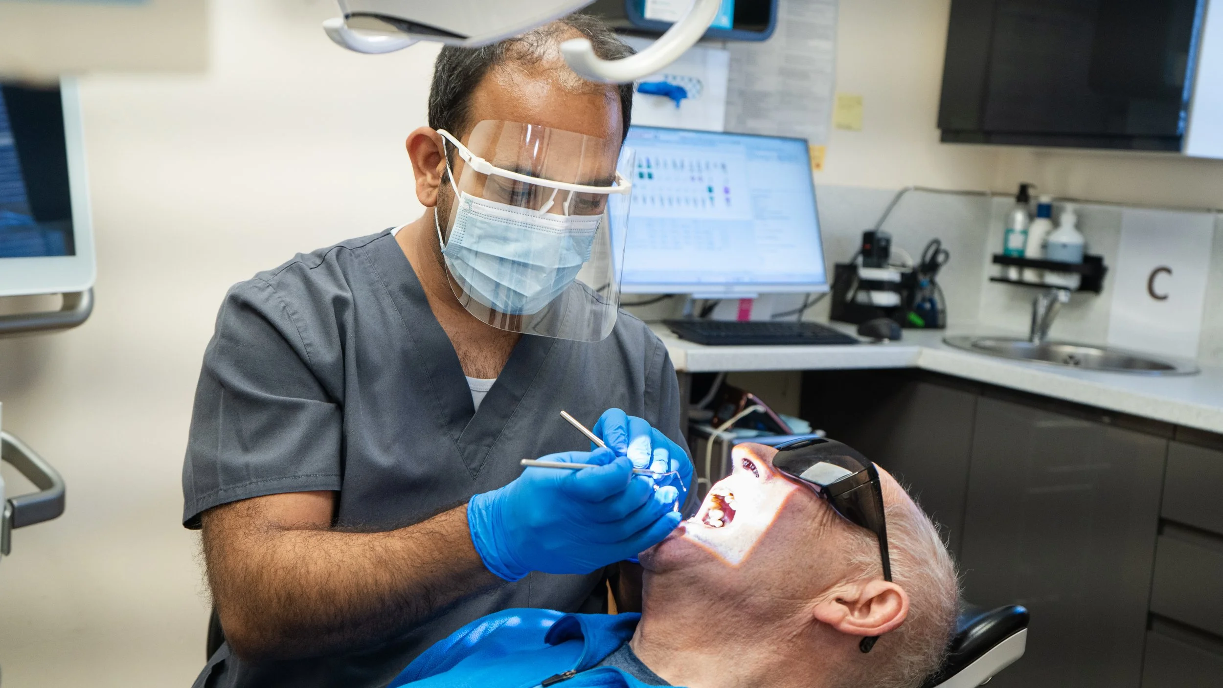 Dentist performing a routine dental check-up on a patient.