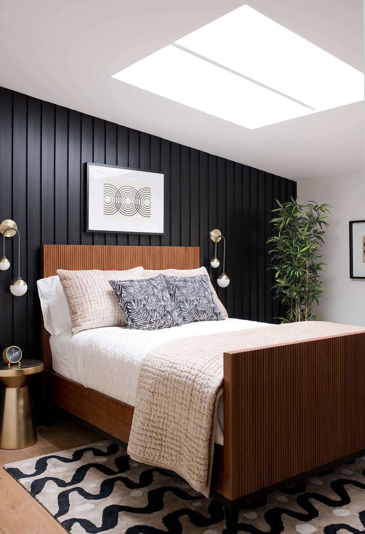 Guest bedroom with black paneled accent wall.