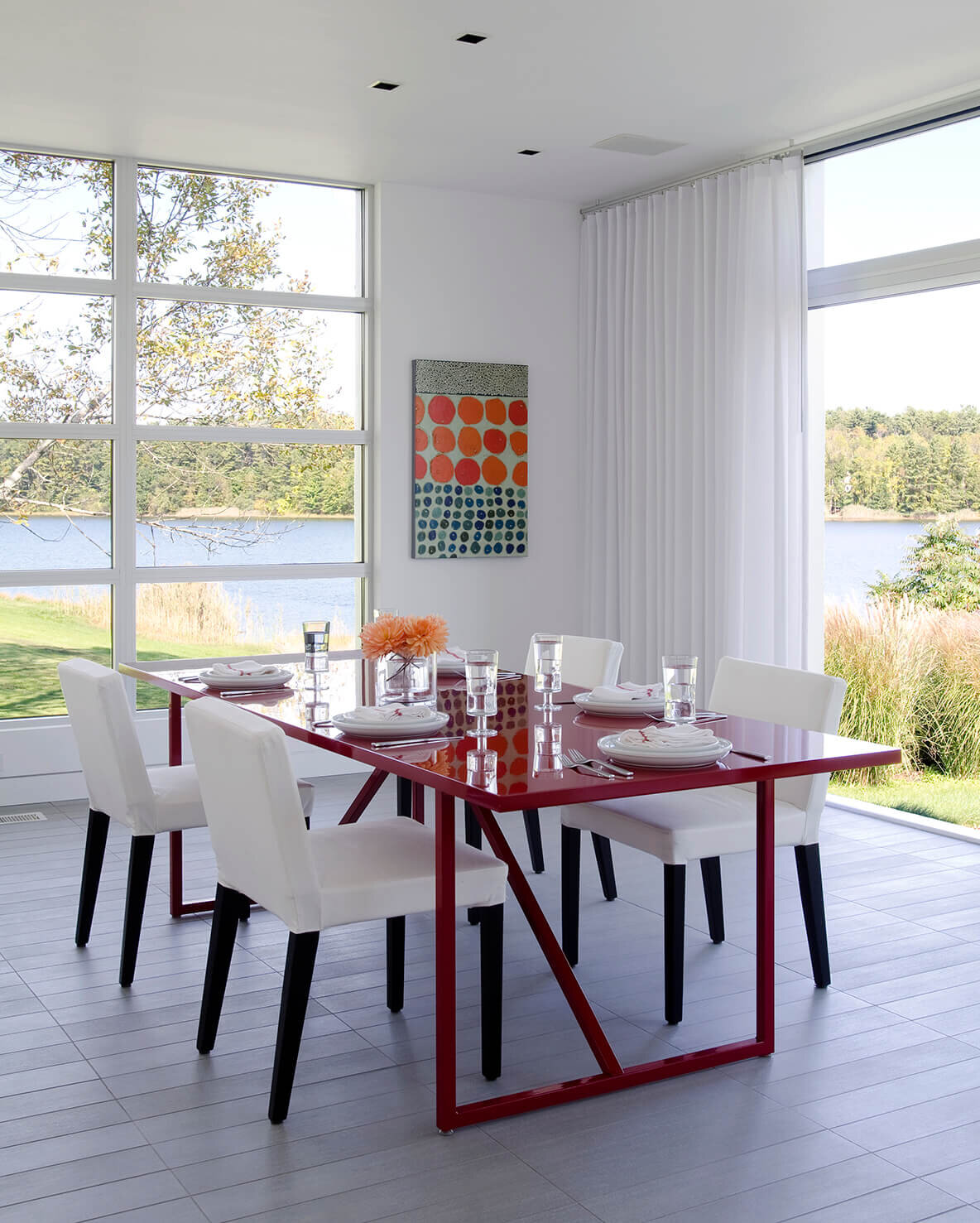 Dining room with red table with views of the ocean.