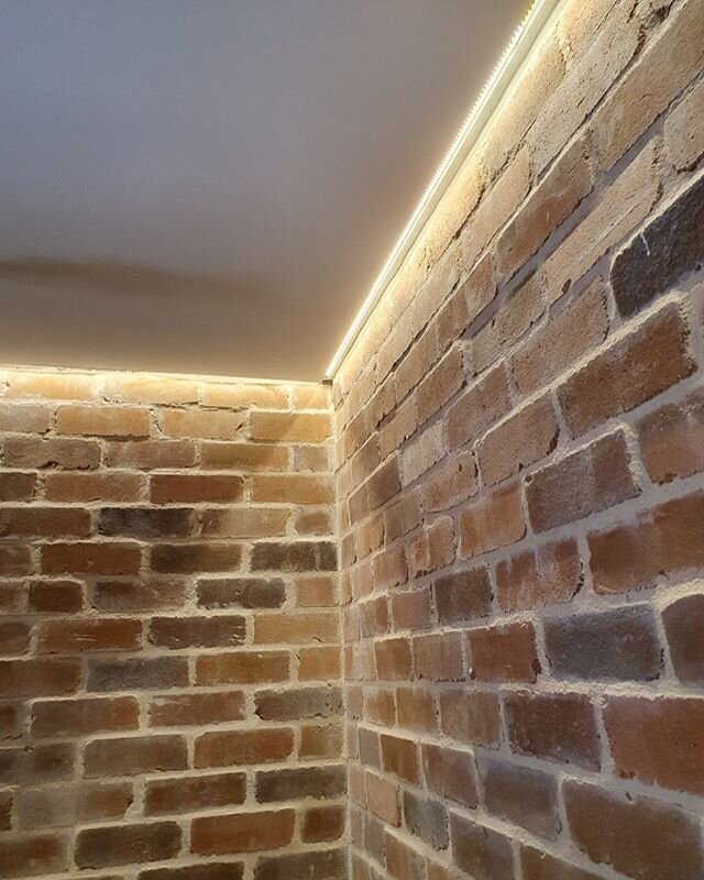 LED strip light casting shadows on our recycled brick foyer cladding at the Paddington Boarding House