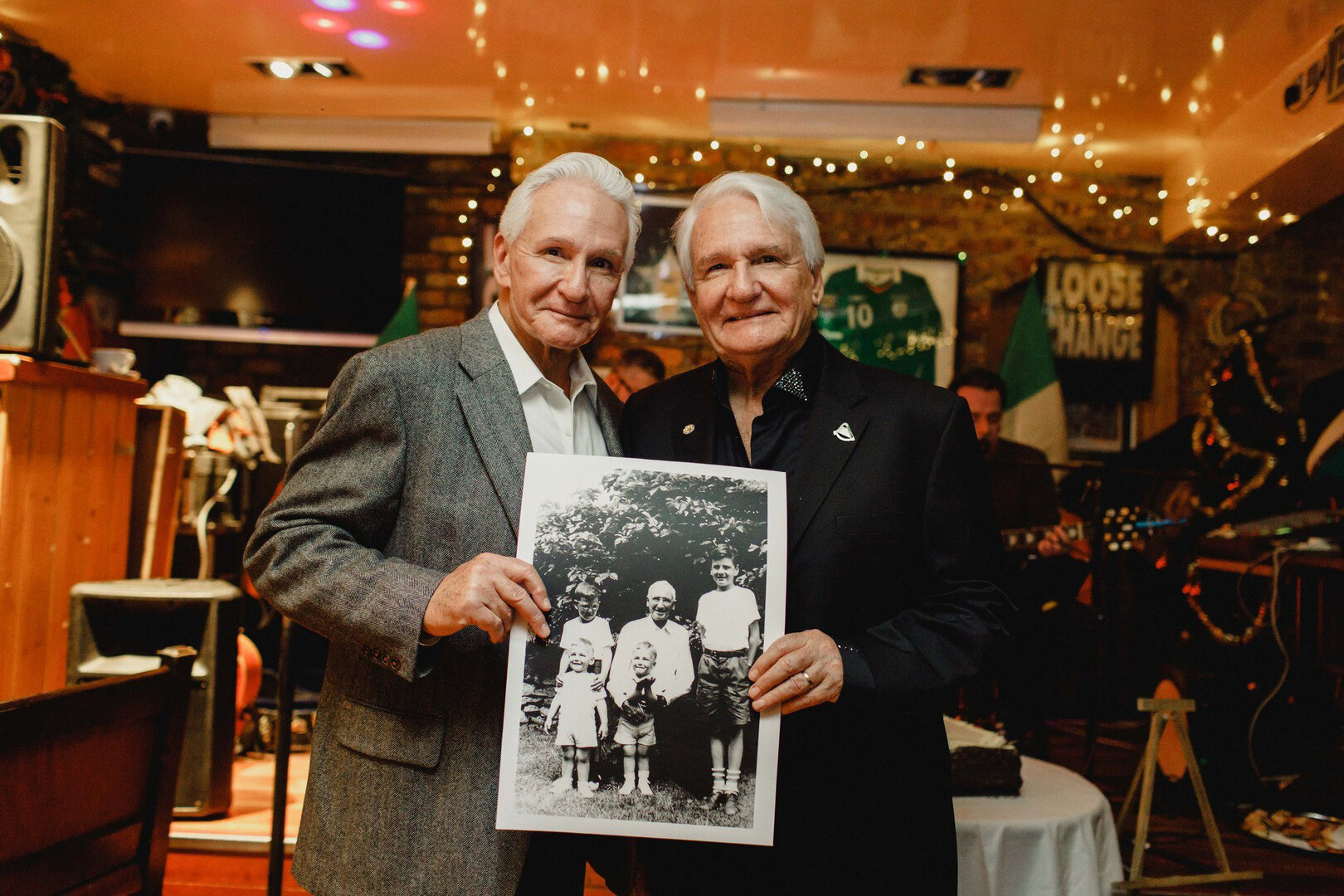  At my Irish citizenship party, my twin brother Brian and me with a photo of our grandfather and our brothers. 