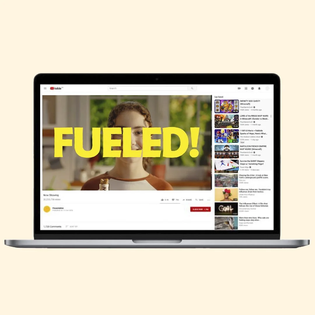 Laptop displaying a YouTube video with the word "FUELED!" in large yellow letters over a child's face.