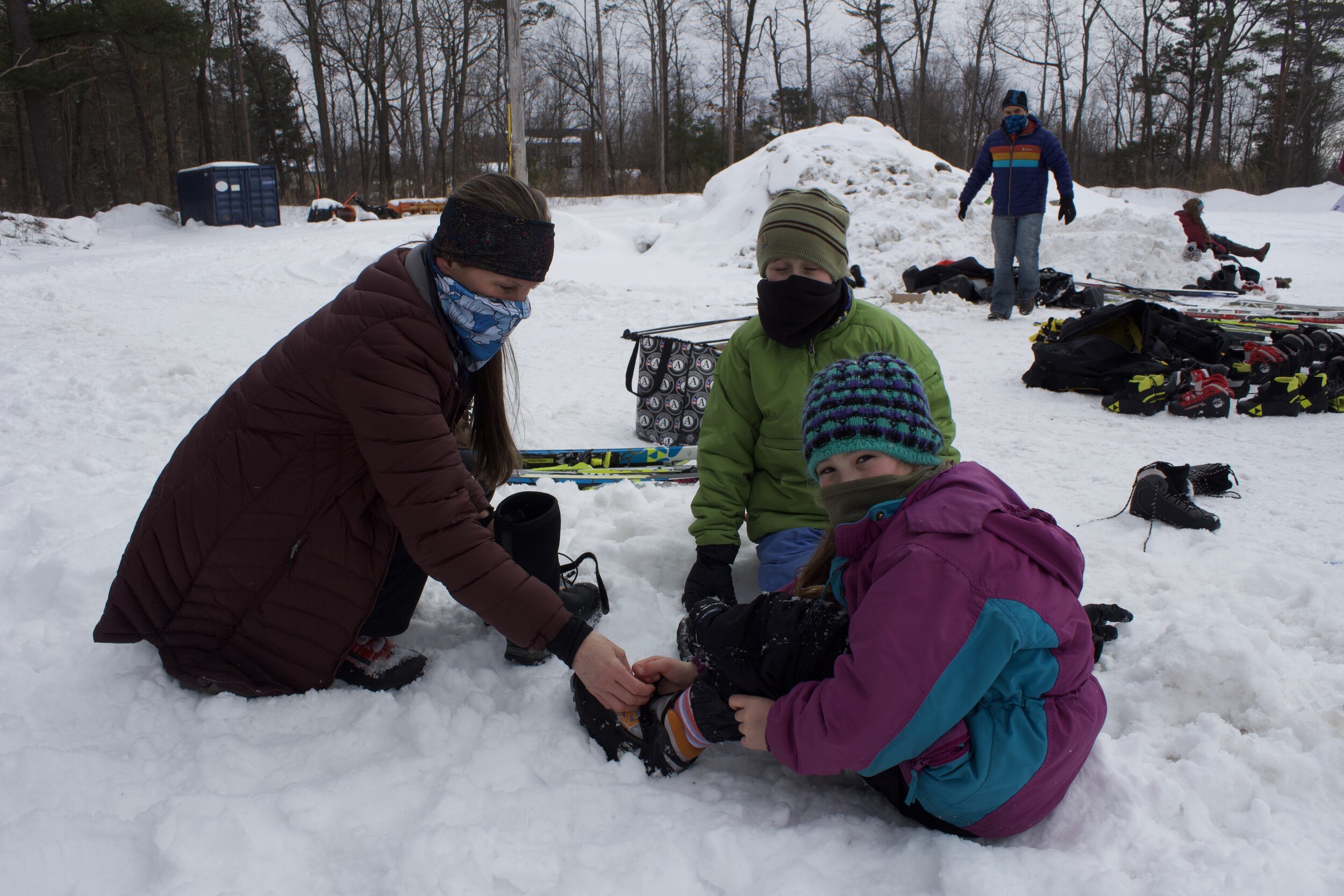   Mother Cathy helps her daughter Amelia get her ski boots on before heading out onto the trail together.  