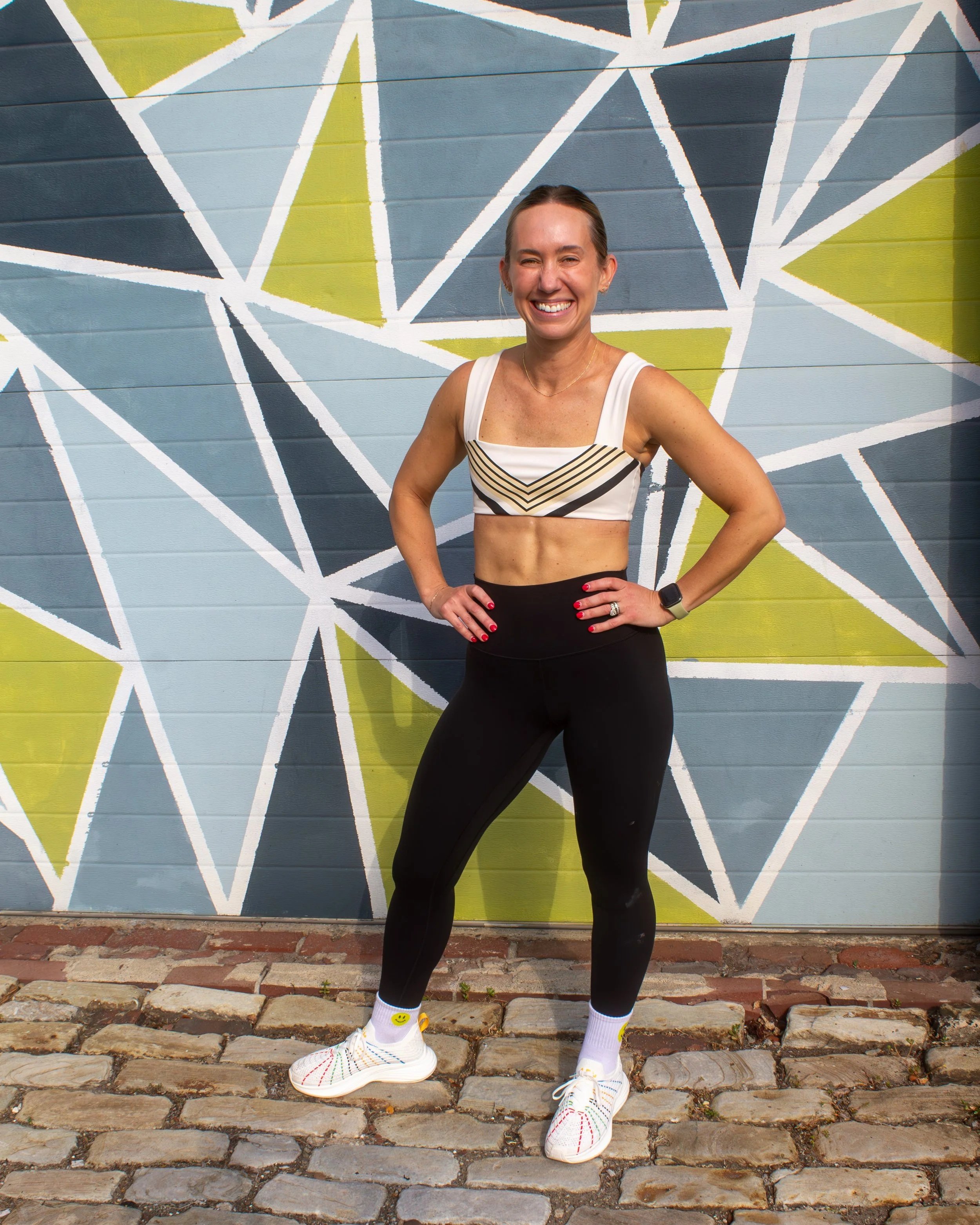 Instructor posing in front of a colorful wall for a photoshoot