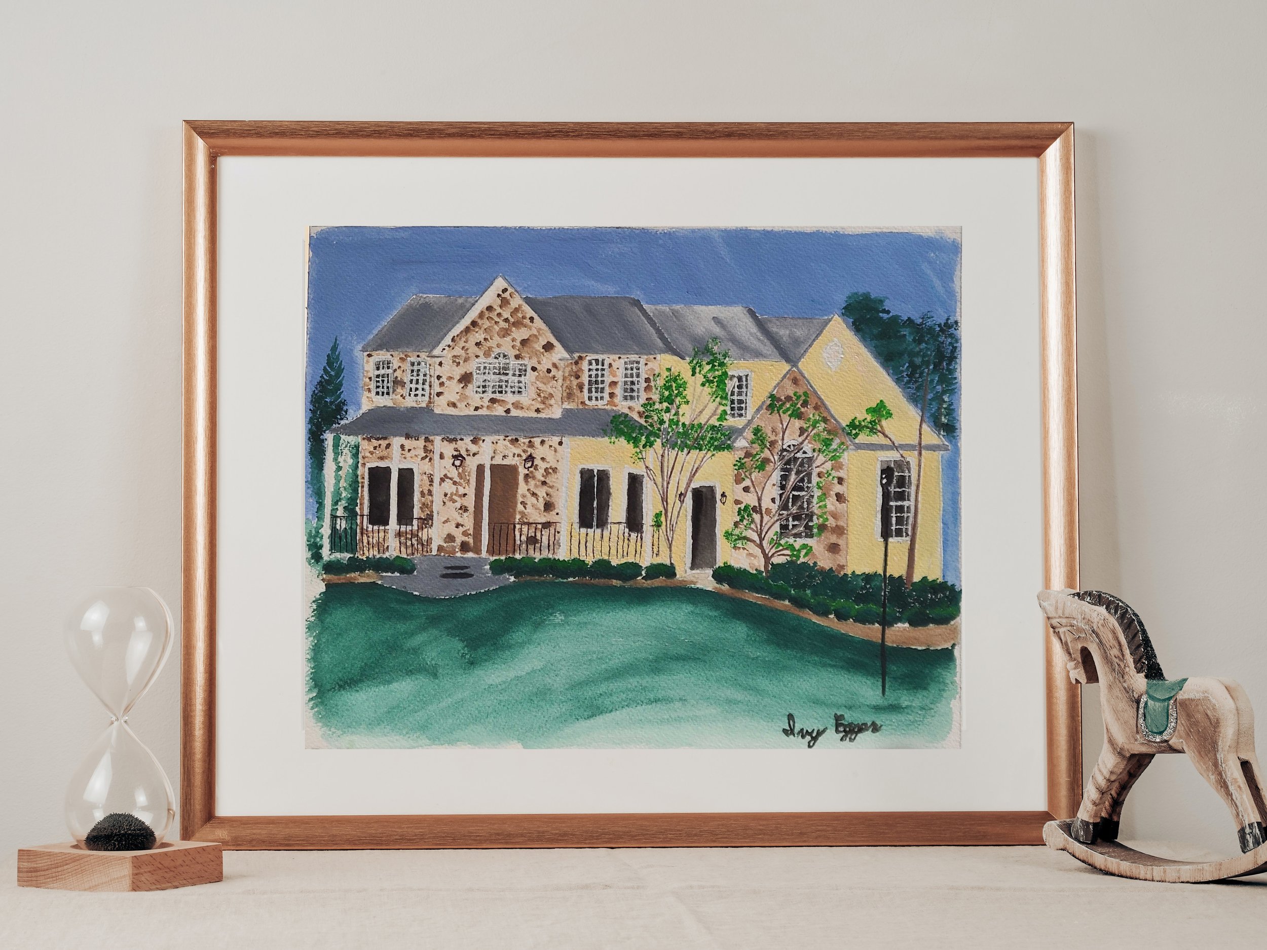 gold framed painting, yellow, brown house, green grass, trees