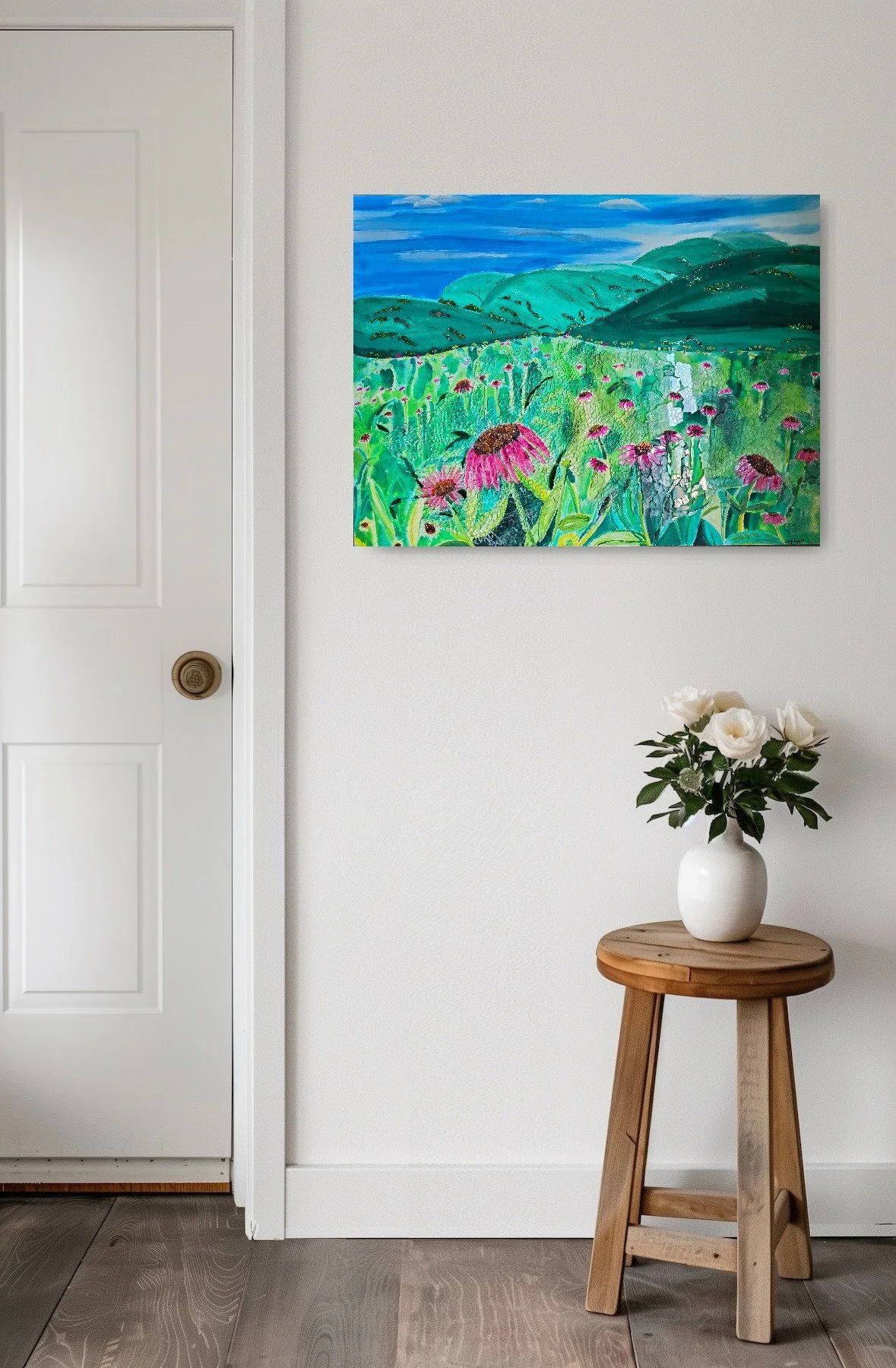 Artwork on a wall above a vase-painted blue sky, green mountains, mosaic glass field of pink coneflowers, green leaves