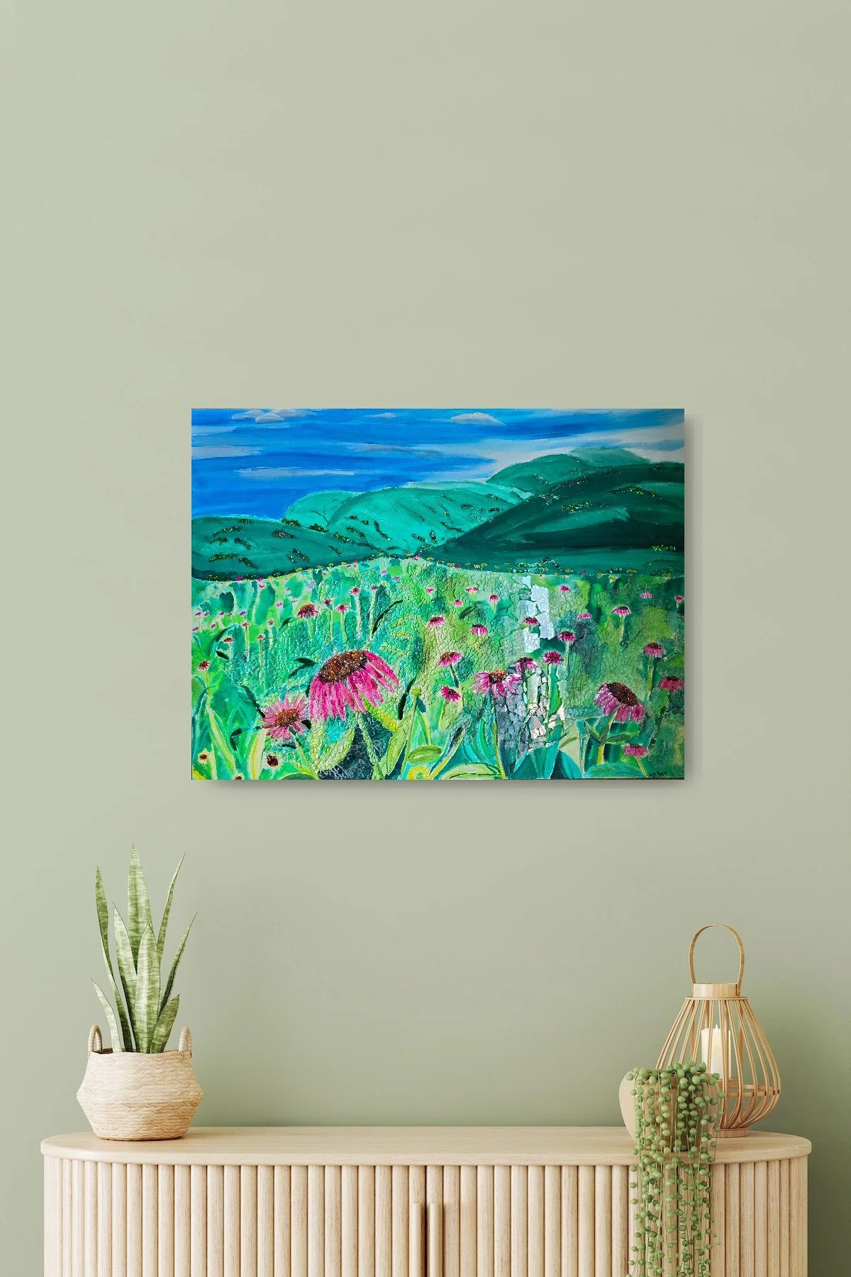Artwork on a wall above a vase-painted blue sky, green mountains, mosaic glass field of pink coneflowers, green leaves