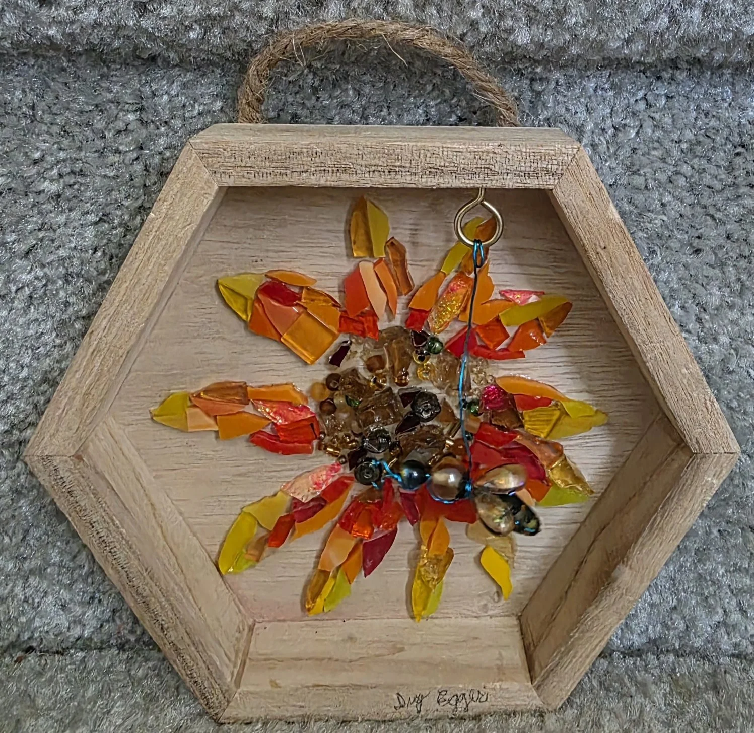 Artwork: wooden hexagon shaped frame around glass sunflower, honeybee