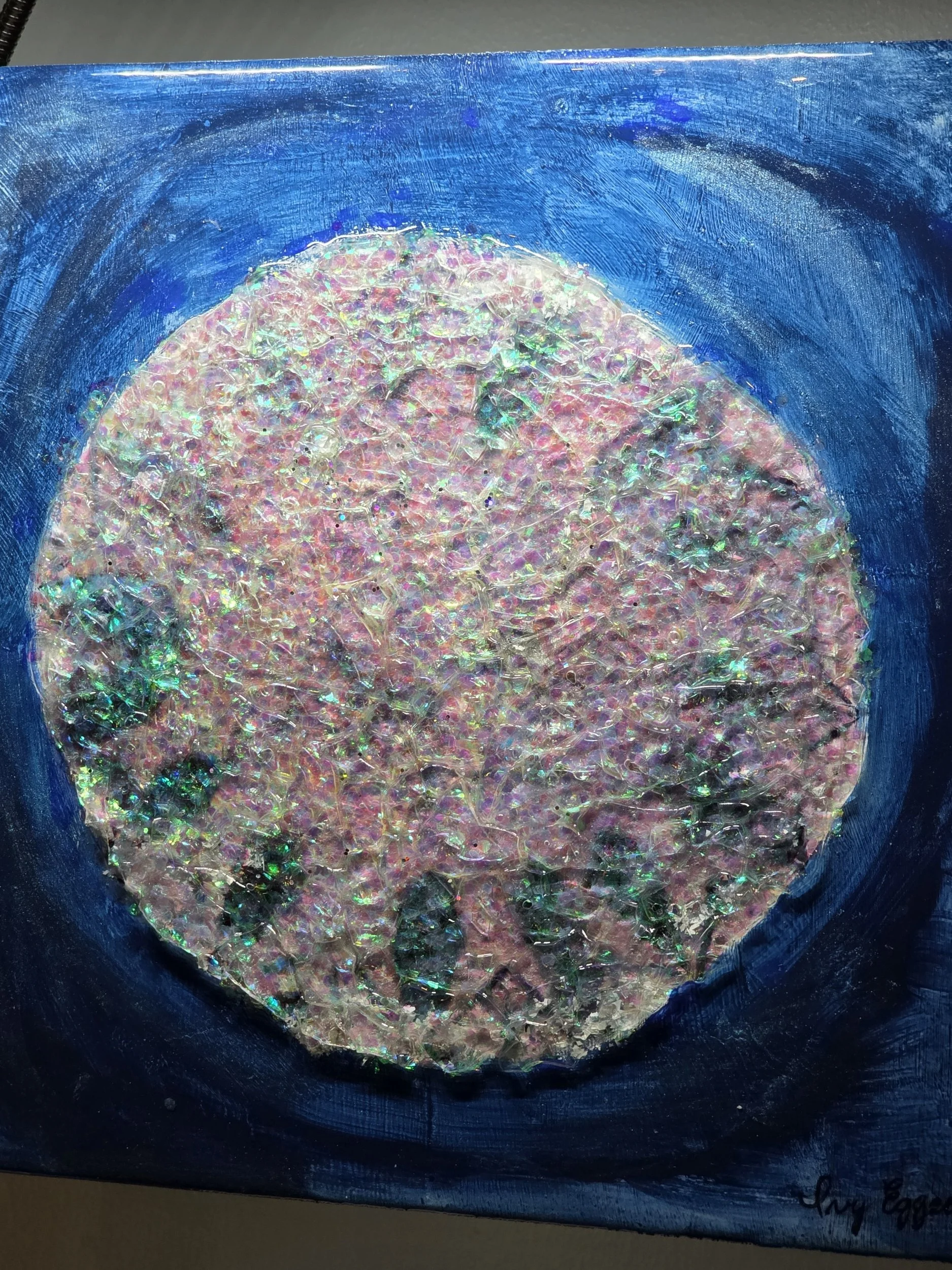 artwork: blue background, glittering white blue circle resembling a diamond