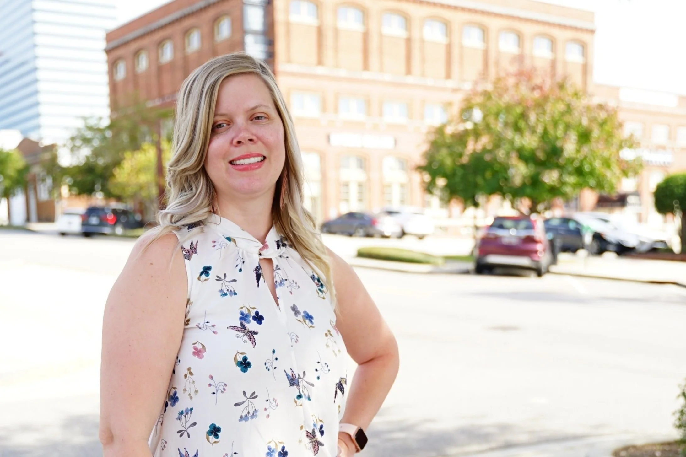 A woman standing with one arm on her hip in a city setting.