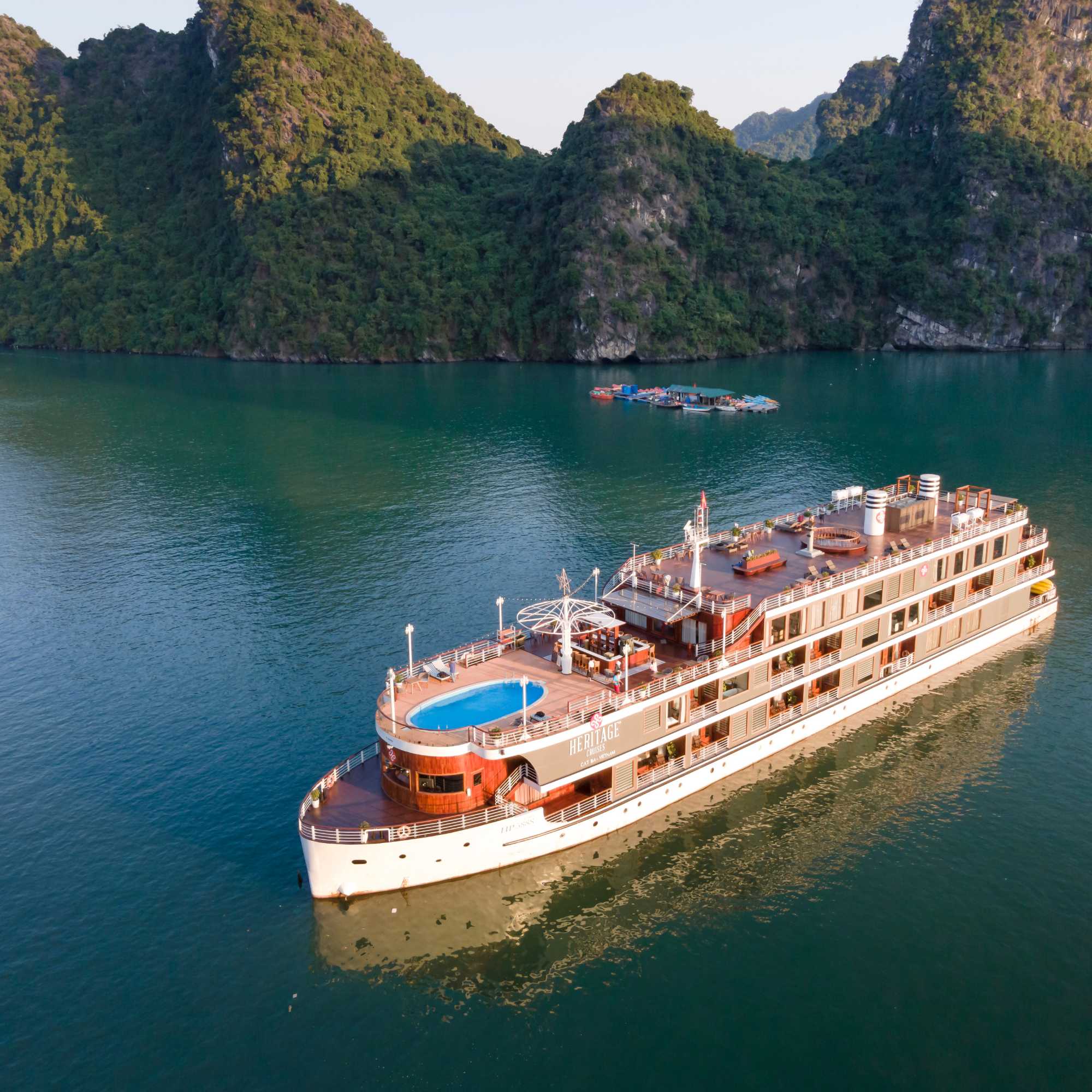 A Heritage Cruise ship sits in a river with a beautiful cliff behind it