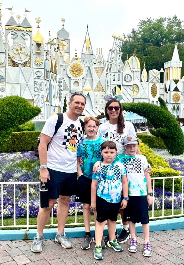 Family in front of It's a Small World attraction at Disneyland.