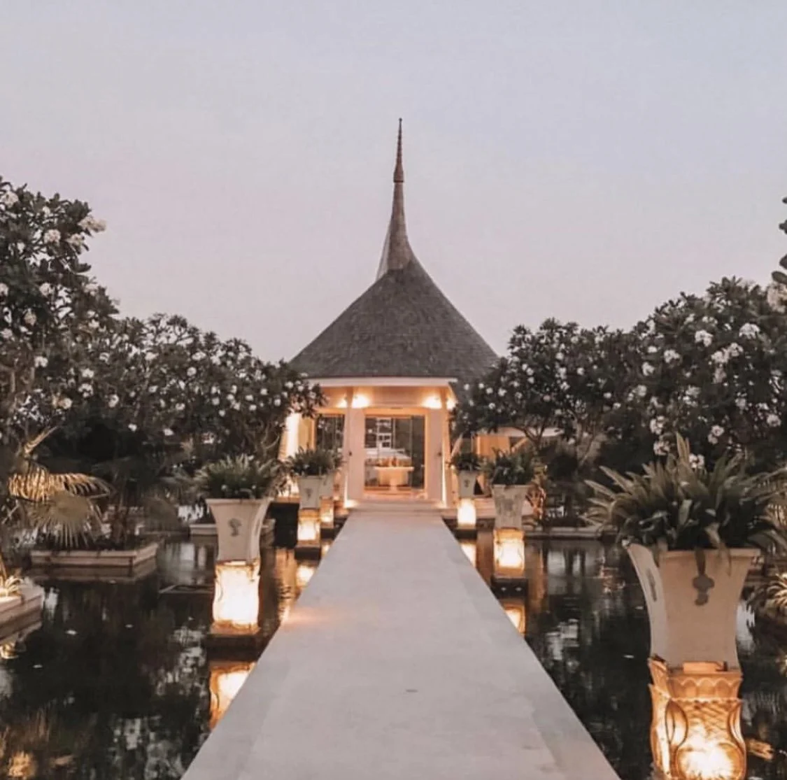 Elegant aisle leading to our love pavilion illuminated by lights at sunset.