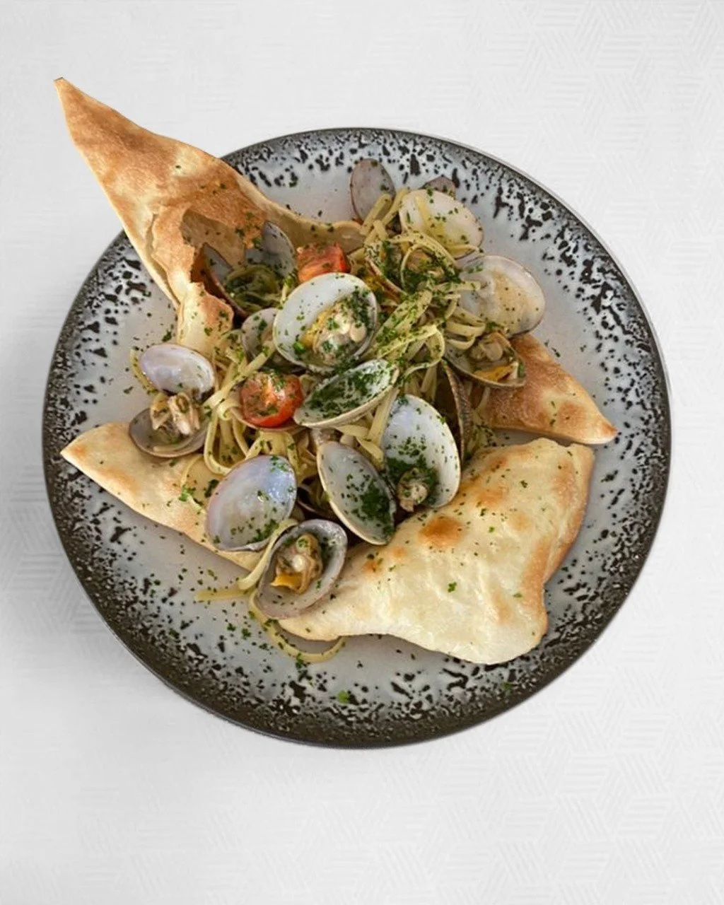 Wedding in Sardinia, our special opia  seafood linguine with clams, cherry tomatoes, and herbs, garnished with pane carasau.