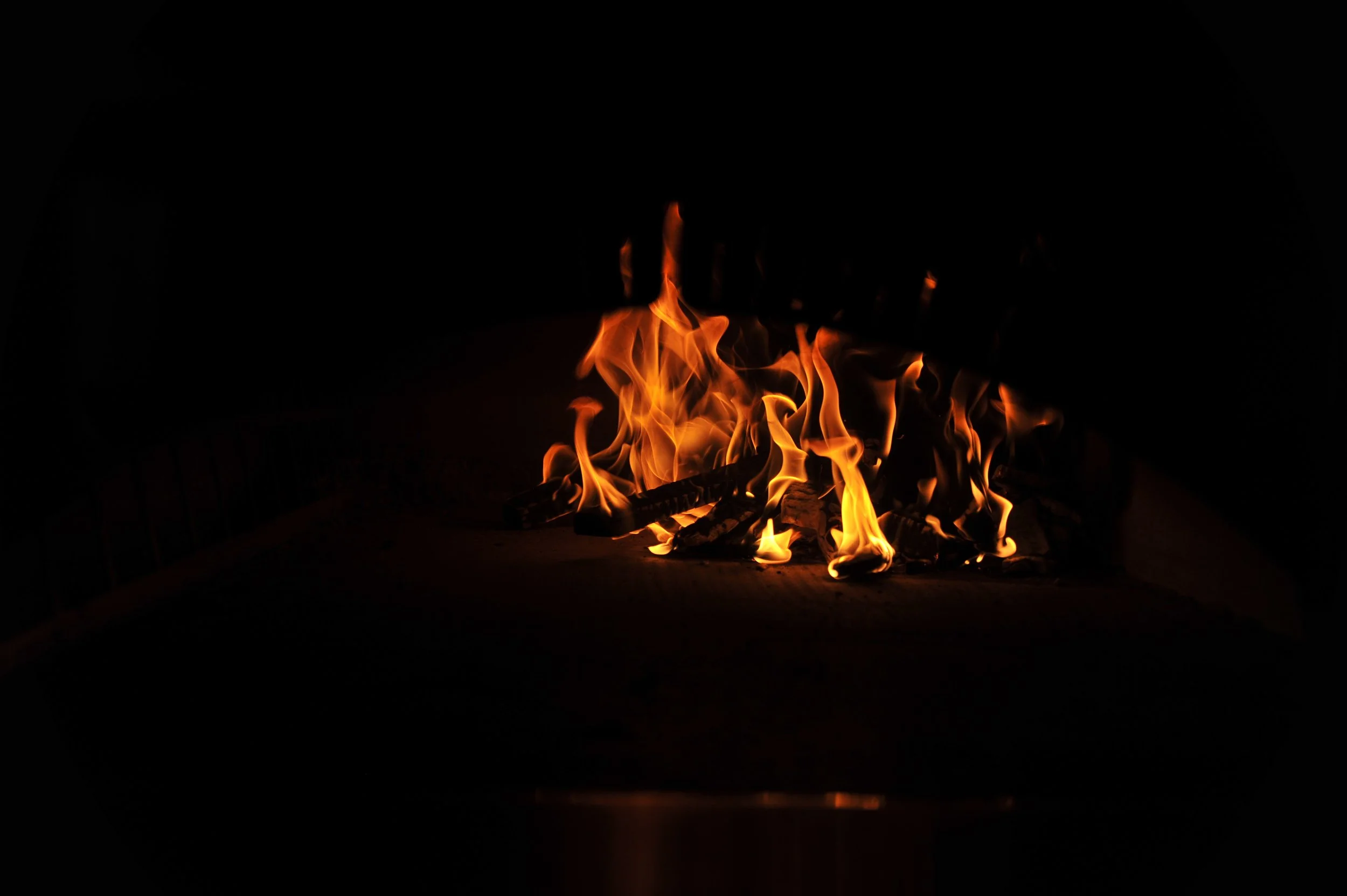 A dark room lit only by the flames of the wood-fired oven inside James Beard Award nominated East Nashville restaurant, Lockeland Table.