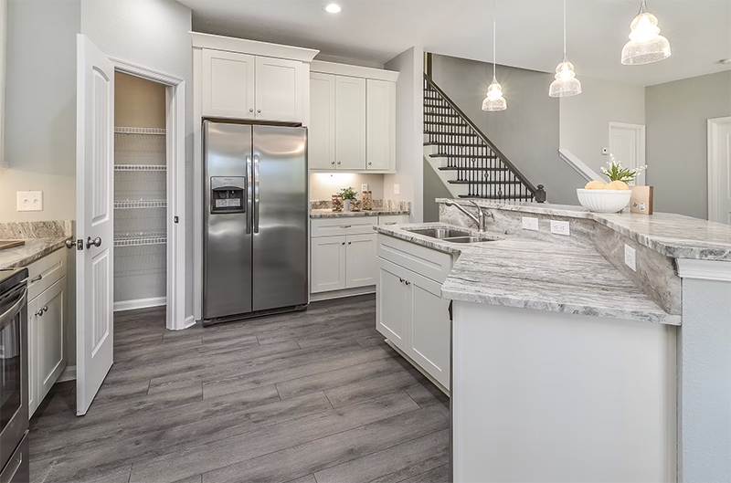 Kitchen view of island and refrigerator