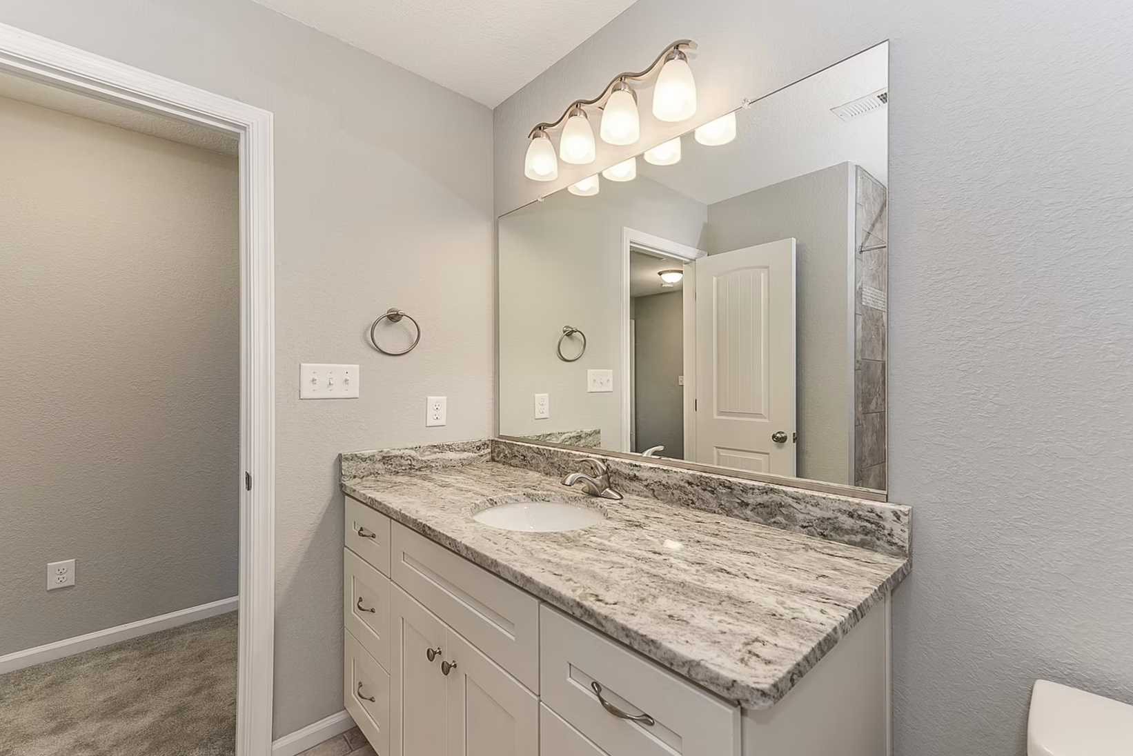View into hall bathroom at vanity