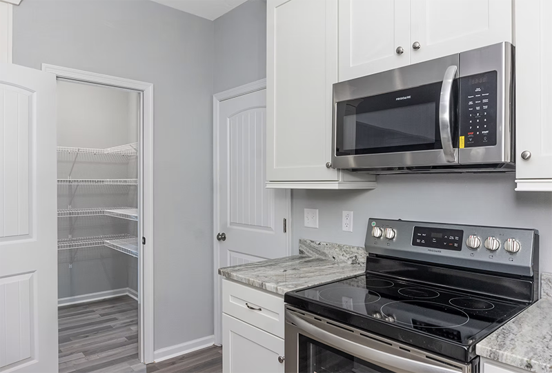 View of stove and kitchen pantry