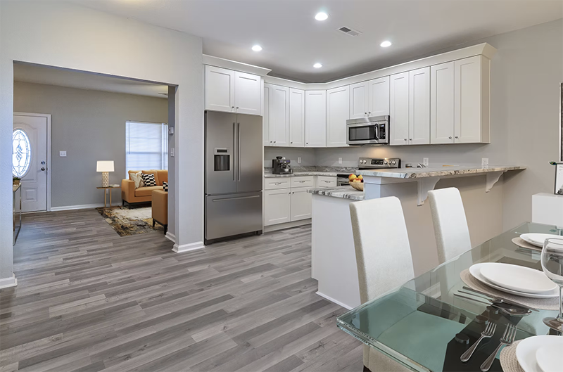 View of kitchen and living space from dining space