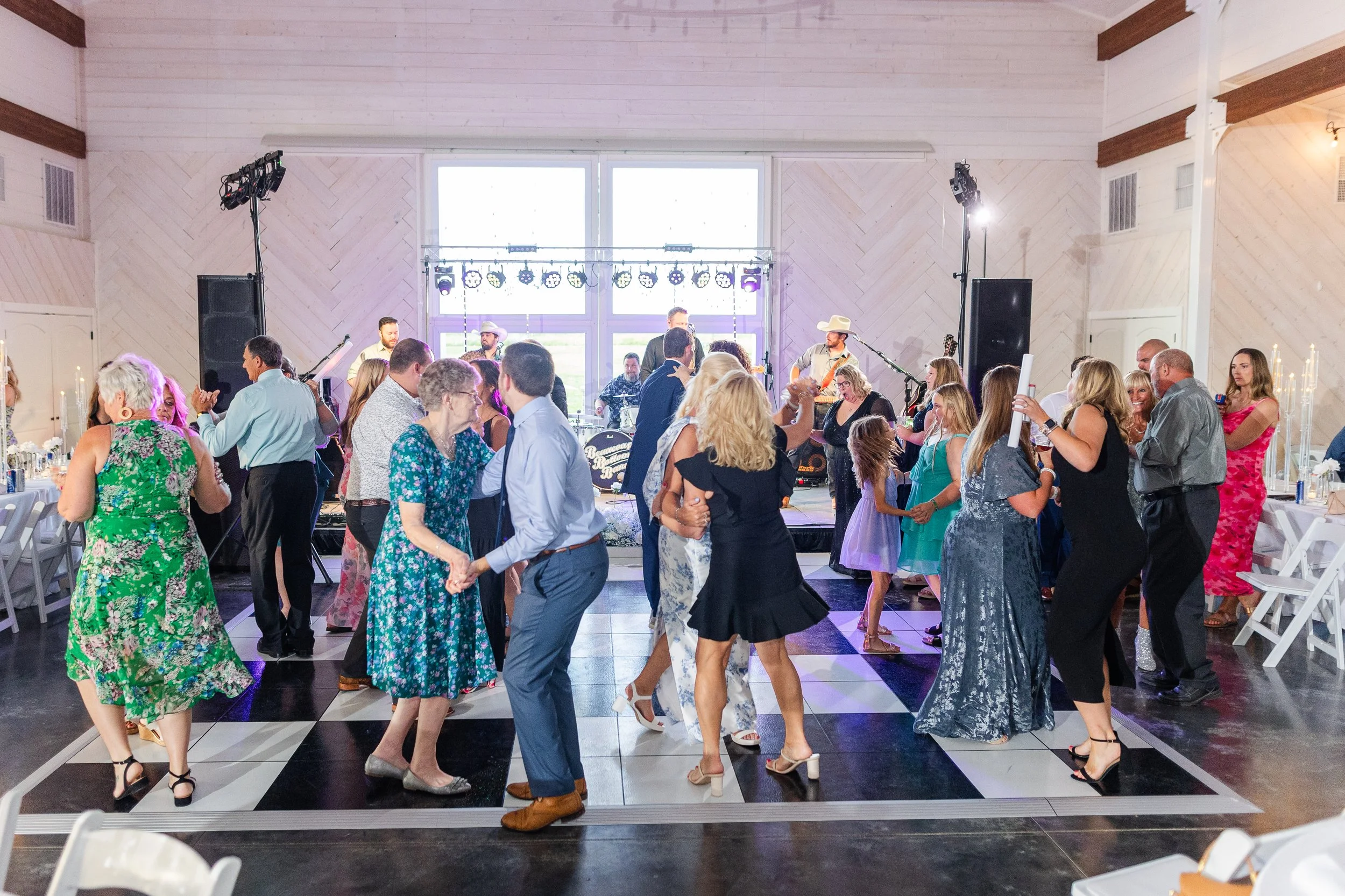 Guests dancing and celebrating at white barn wedding reception near St. Louis