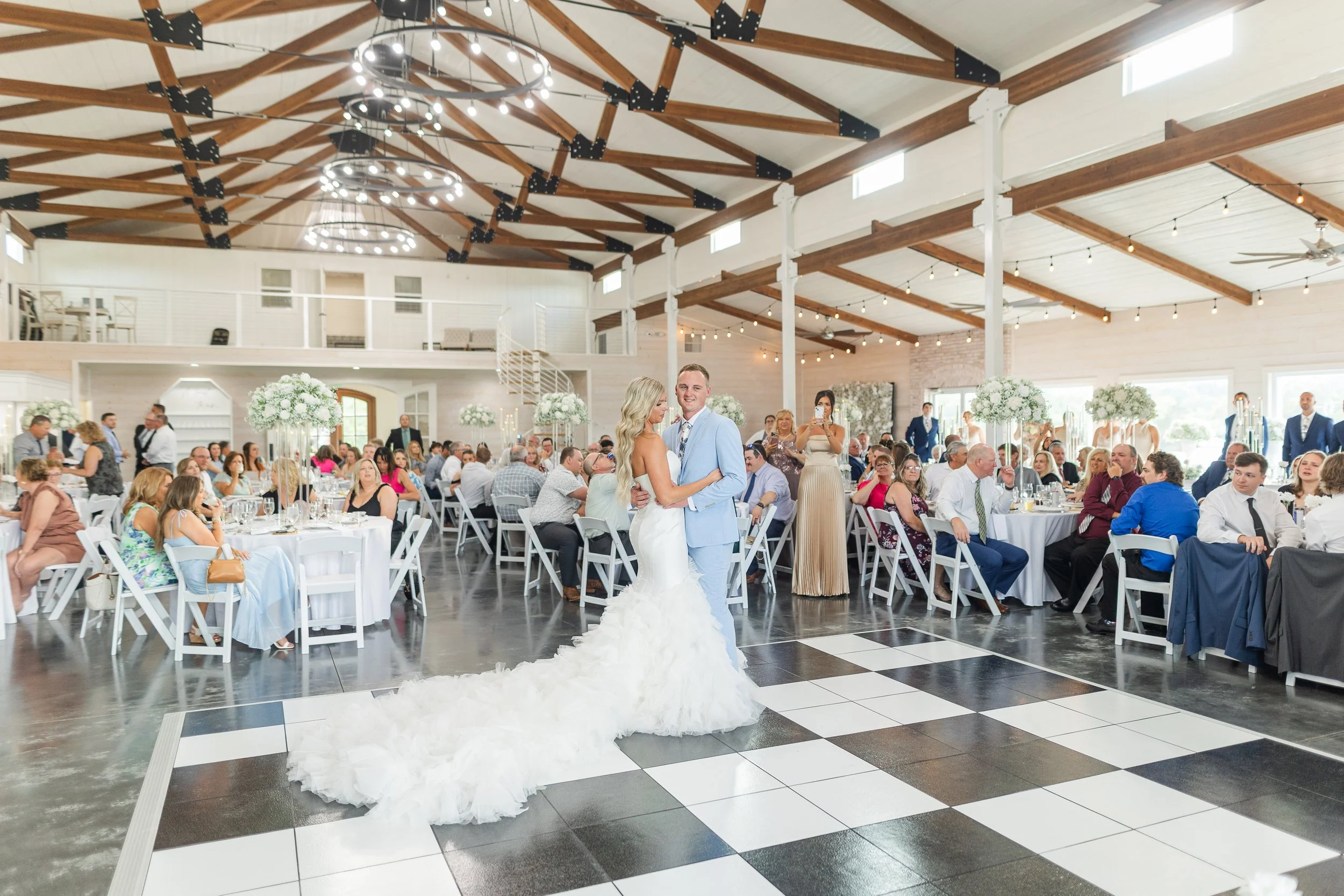 Couple's first dance inside Pebble Creek Farm's elegant white barn reception hall.