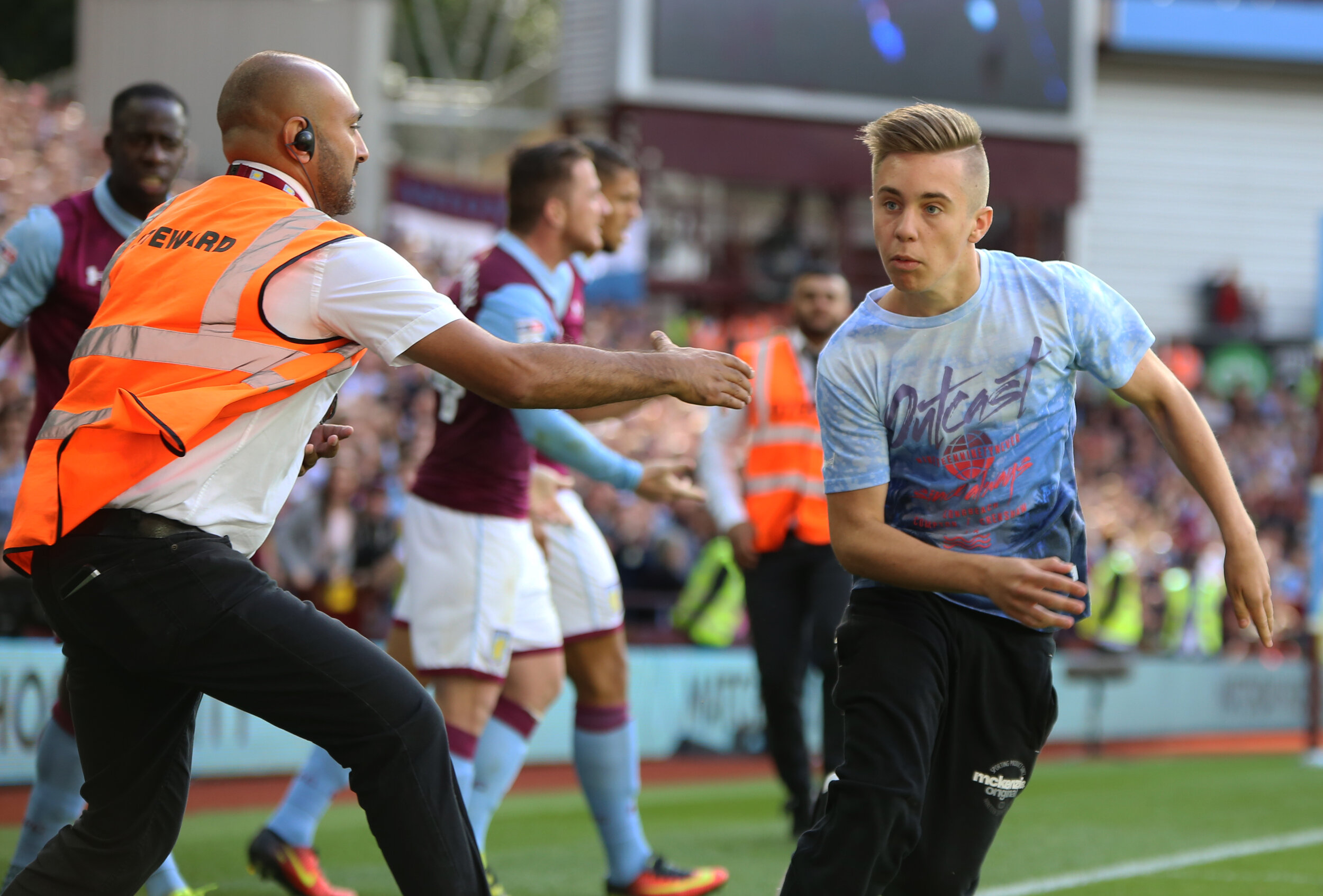 Soccer steward intercepting fan on field