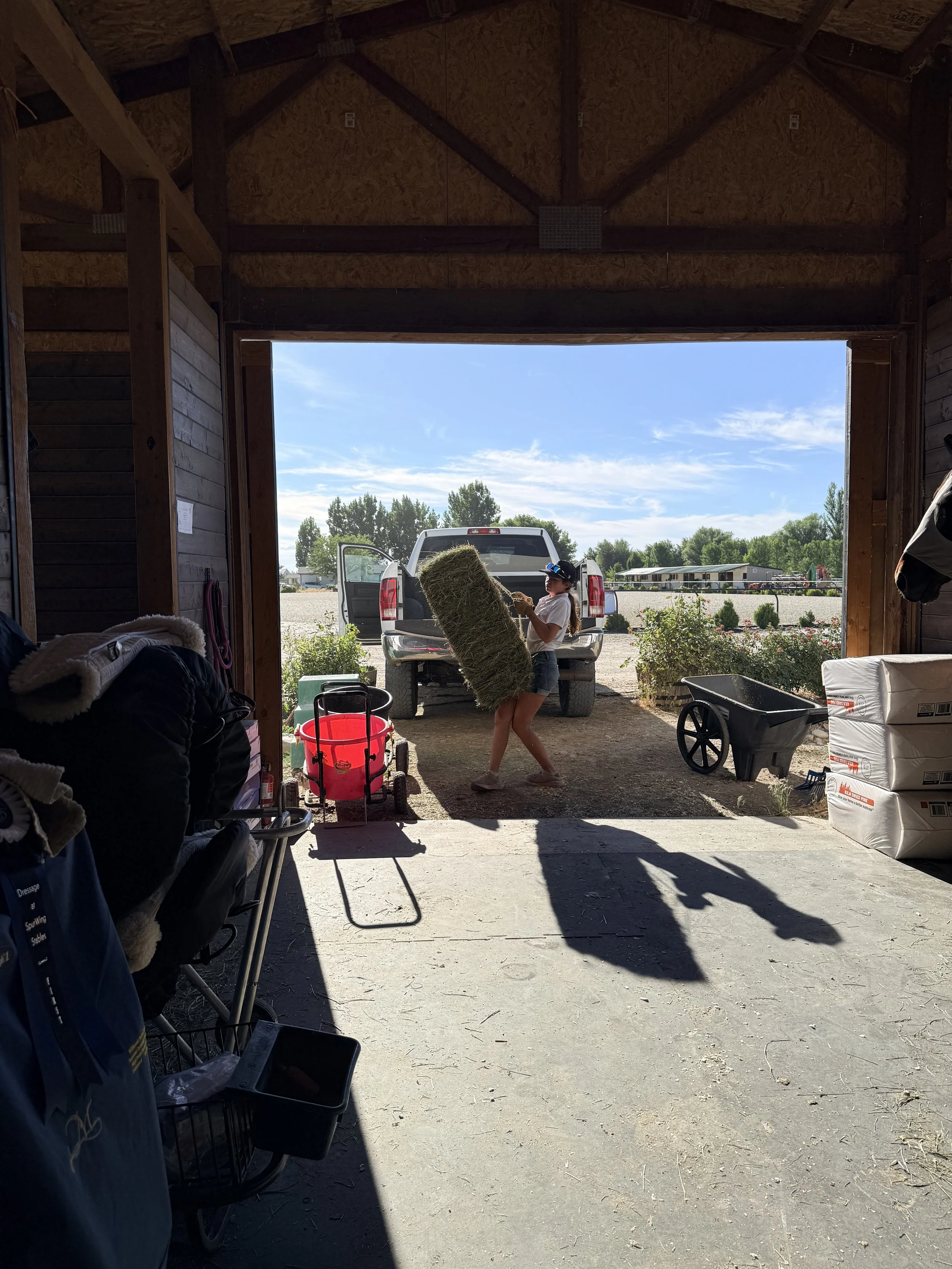 young girl moving hay bale