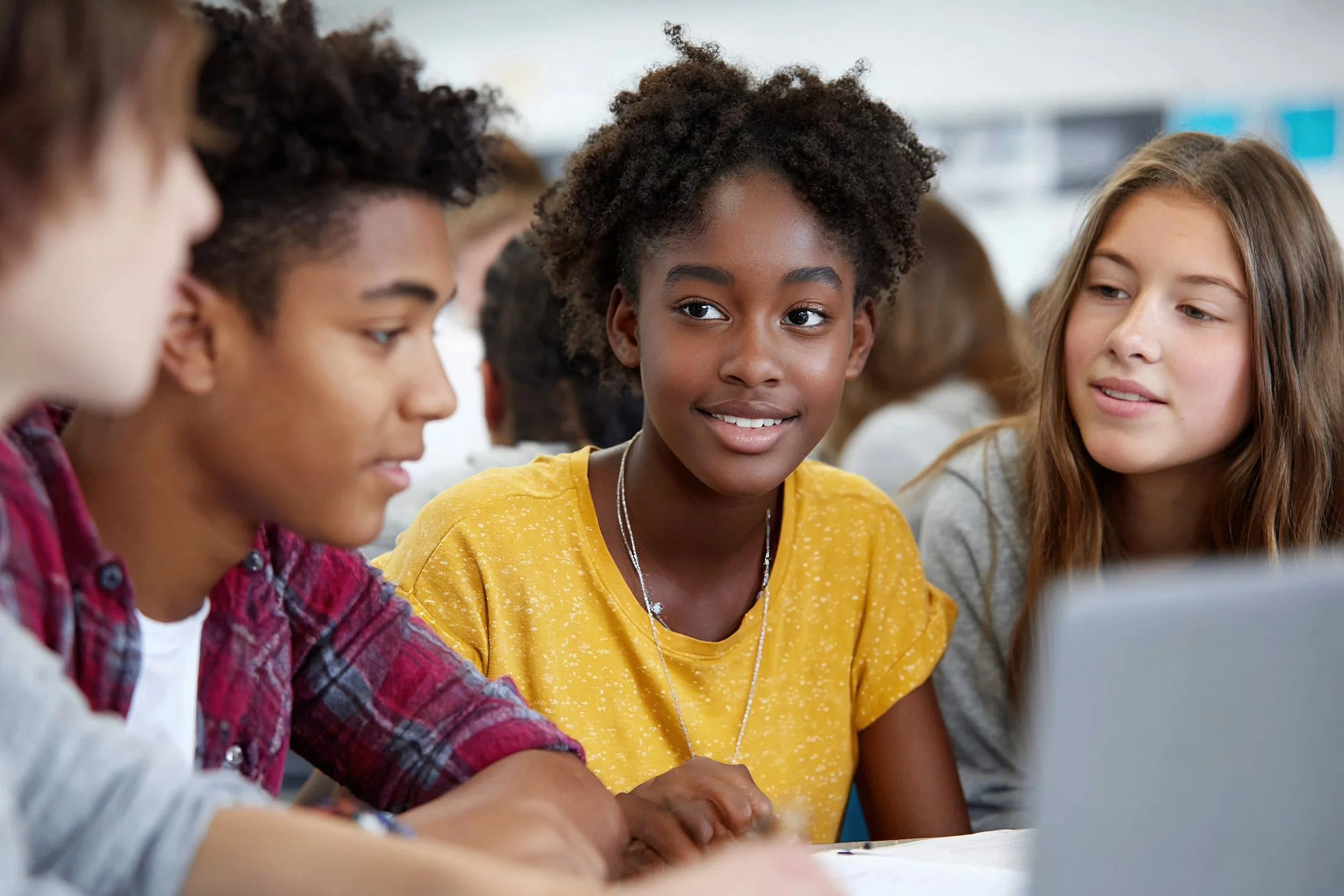 Students collaborating in a classroom demonstrating positive behavior, engagement, and respectful peer interaction