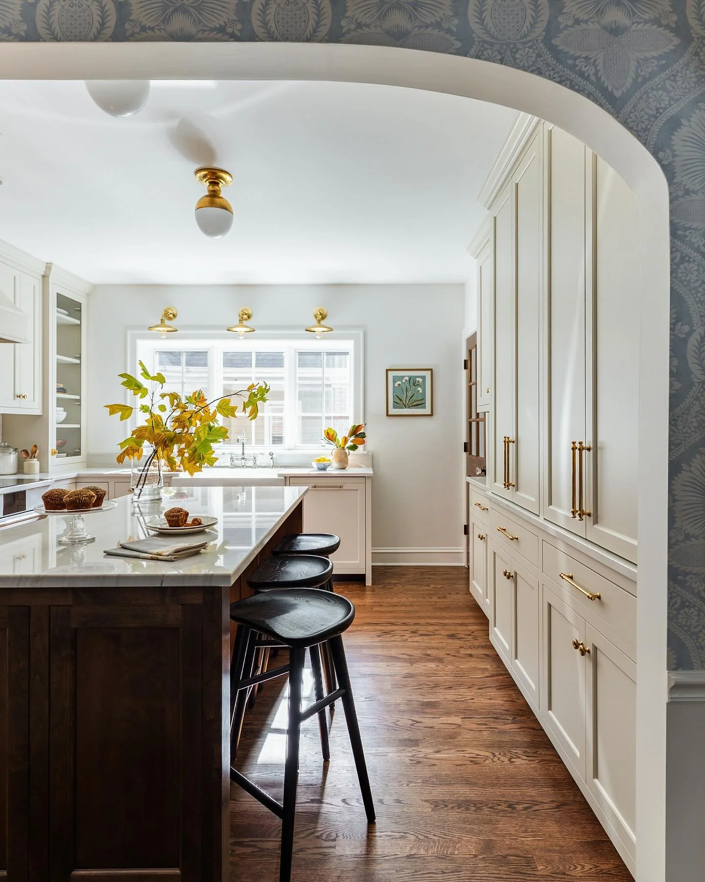 Beautiful spaces only need a little seasonal styling. A few clipped branches of golden leaves echo the warm wood, brass, and glowing light, and suddenly the whole space feels like the season. 🍂

Design: @interiorbloomsdesign 
📷: @juliannegreeninter