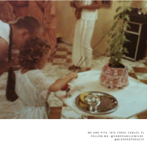 A young girl and a man looking at a tray of bananas and a small Christmas-themed cake on a table during a family celebration.