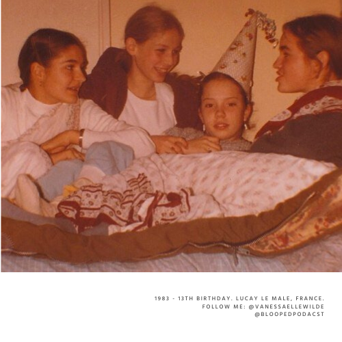 Four girls sitting around a girl in a bed wearing a birthday hat, celebrating her birthday.