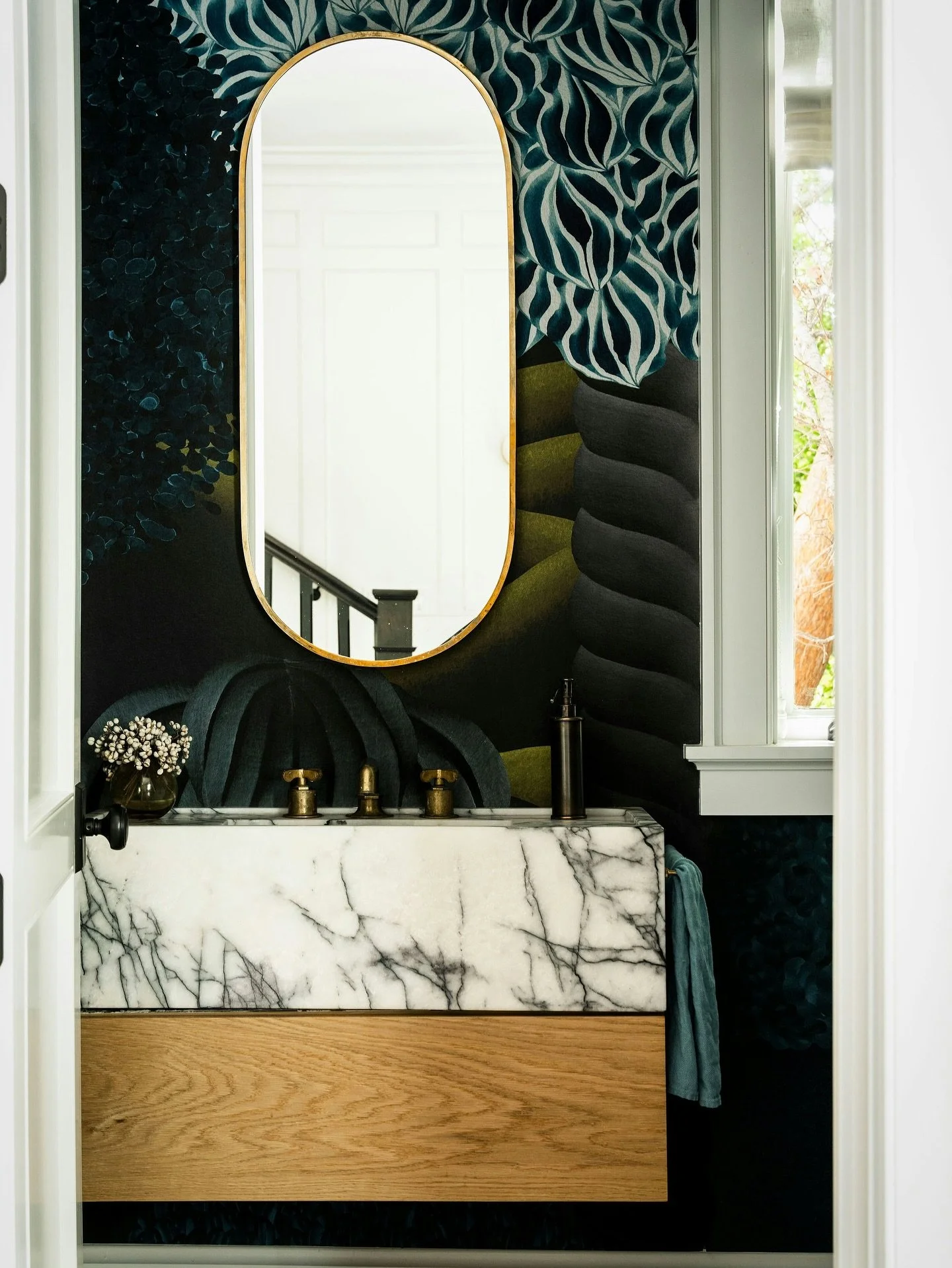 The powder room at Lower Mandeville proves that even the smallest spaces can make a statement&mdash;moody, layered, and full of character. 

Listed by @livingwestrealestate
Photos by @caterphotography
Styled By @mauricegadsoninteriors