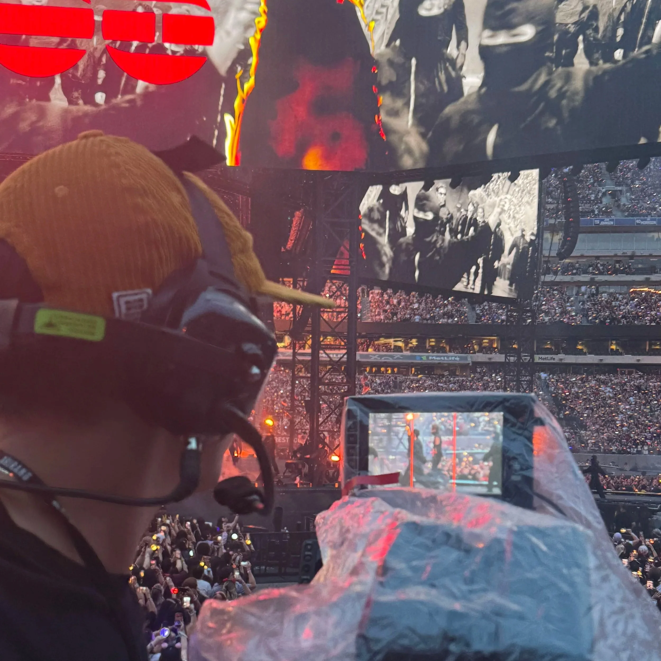 Camera operator filming a live concert at MetLife Stadium