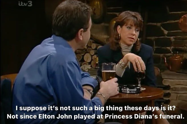 I suppose it’s not such a big thing these days is it? Not since Elton John played at Princess Diana’s funeral.
#emmerdale 
[ID Viv is talking to Terry in the pub. She’s wearing a turtleneck, Terry is wearing a blue shirt and it ho