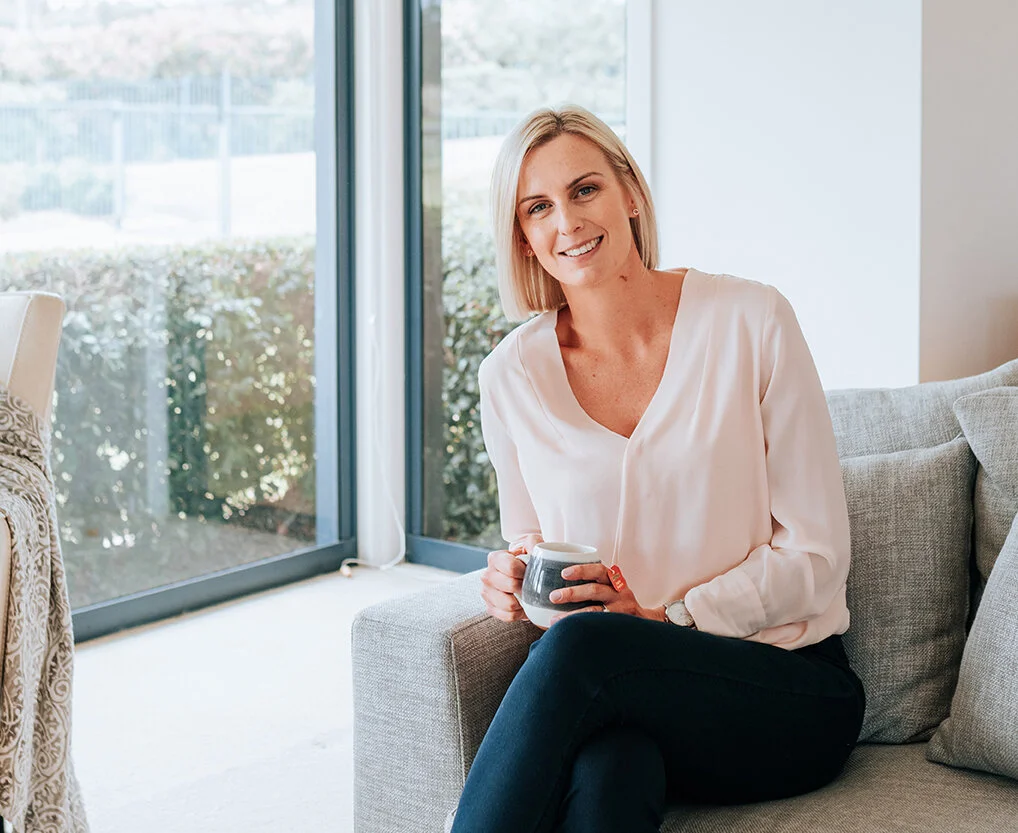 PCOS & Fertility Dietician sitting on lounge drinking tea